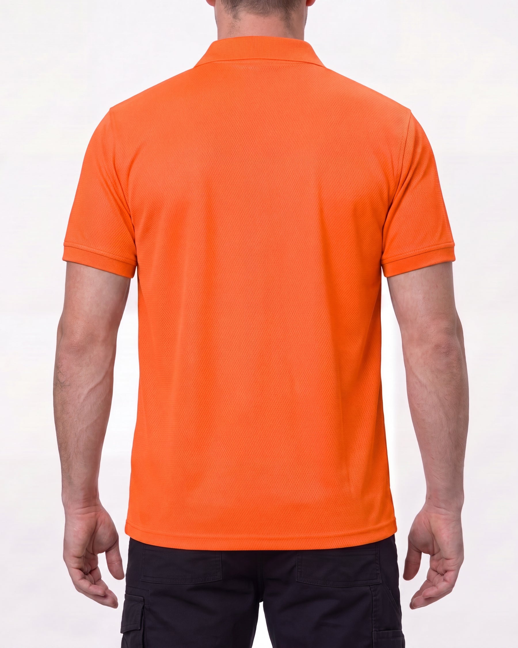 A model wears the STRAUSS Enhanced Visibility Performance Polo Shirt in neon orange with dark work pants and work boots, showing the shirt fit