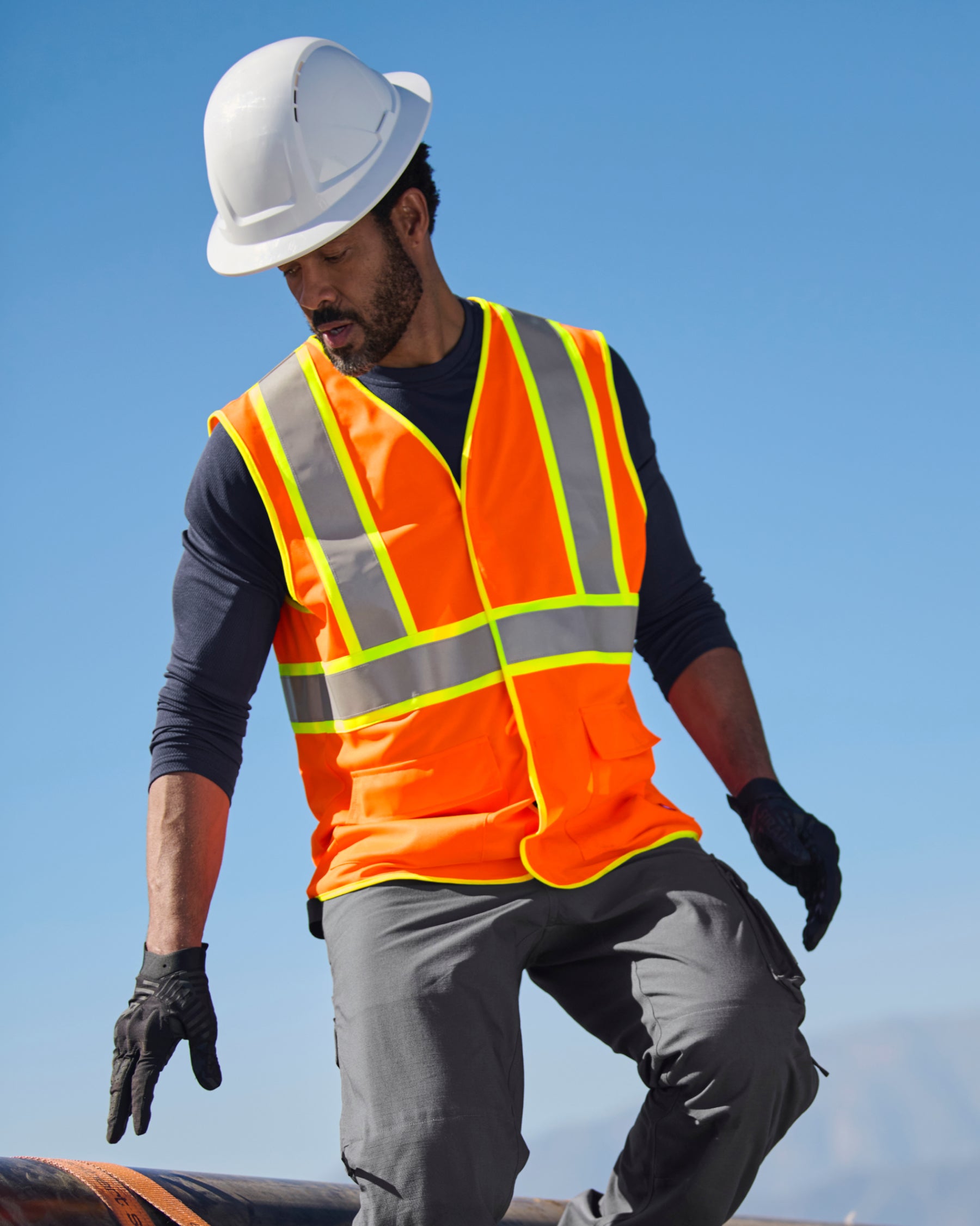 STRAUSS high visibility vest in neon orange shown on an outdoor jobsite
