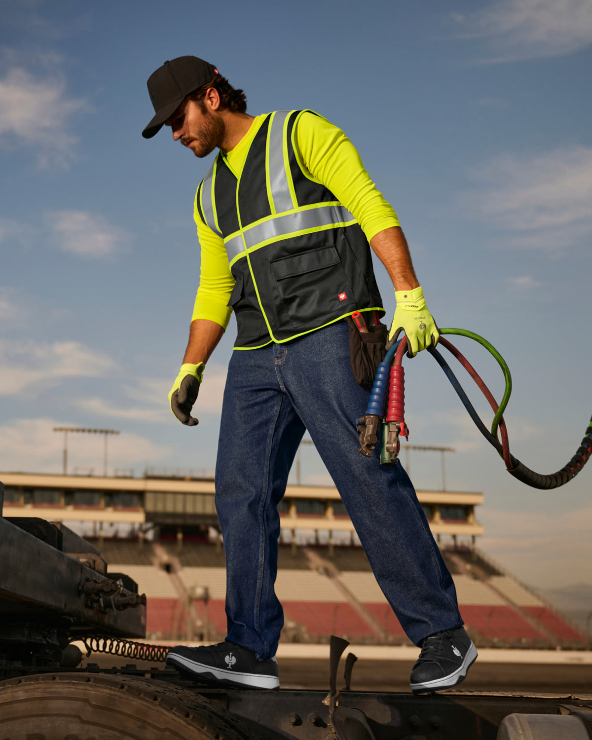 STRAUSS enhanced visibility vest in black shown on an outdoor jobsite