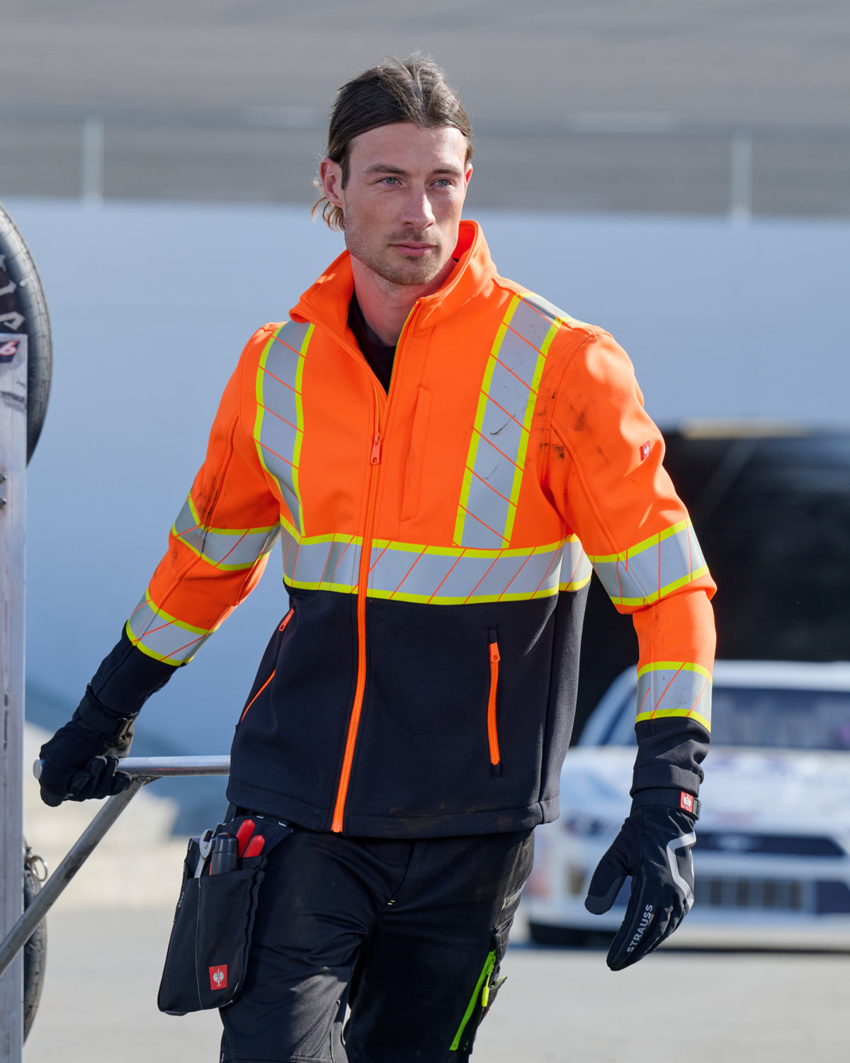 STRAUSS Class 2 high visibility softshell jacket in neon orange and black worn for high-visibility work