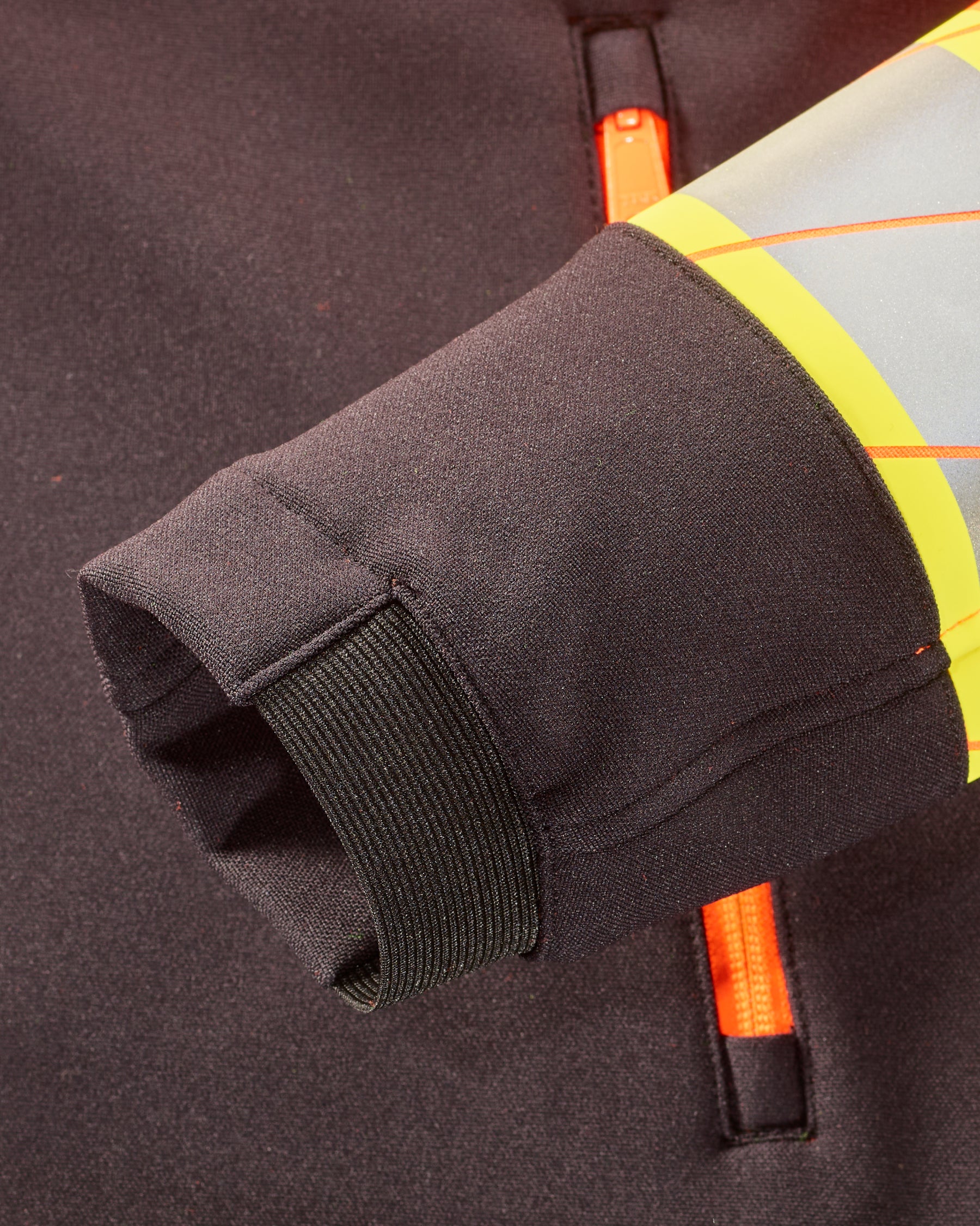 Close-up of zipper and pocket details on STRAUSS Class 2 high visibility softshell jacket in neon orange and black