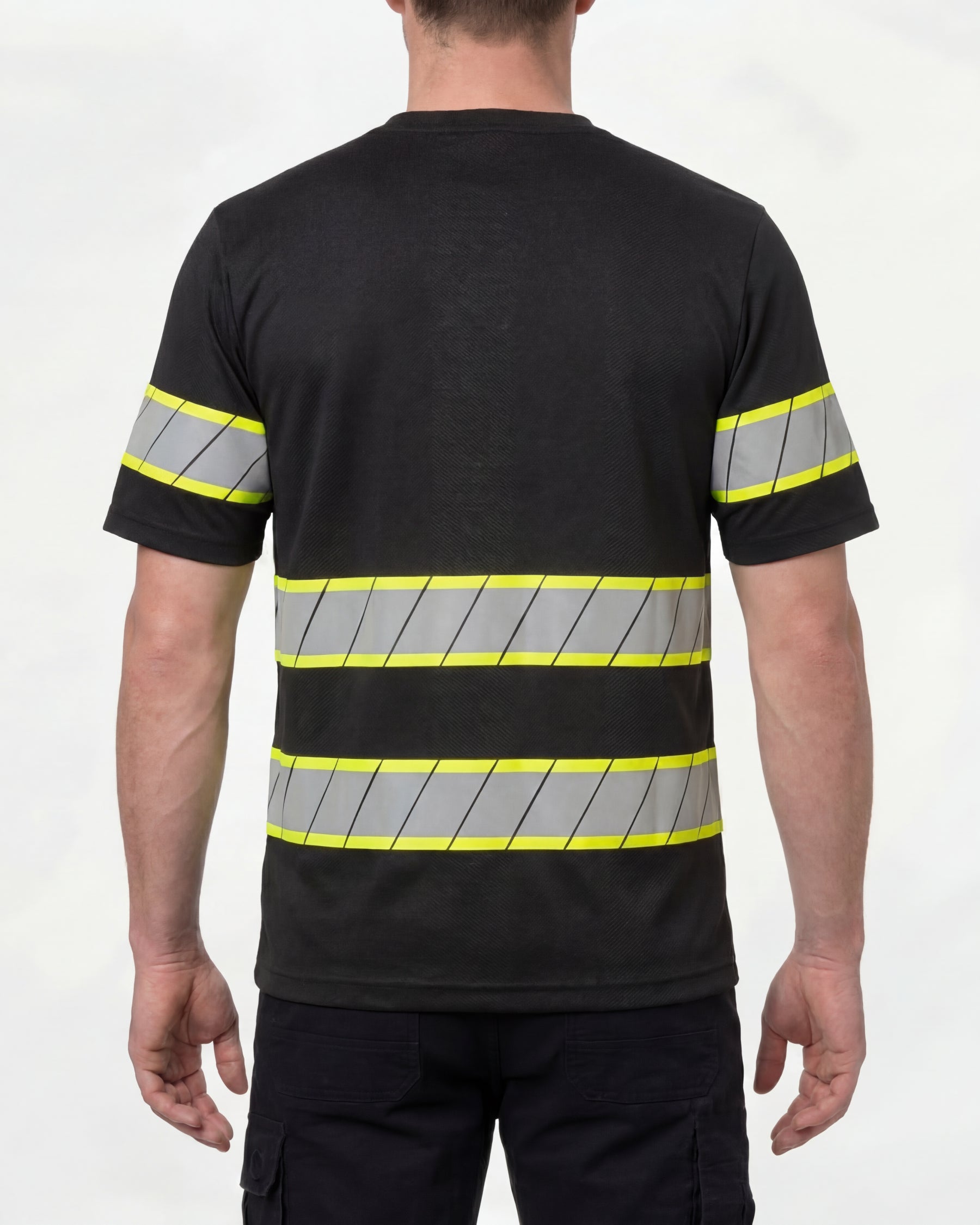 A model wears the STRAUSS Enhanced Visibility T-Shirt in black with dark work pants and work boots, showing the shirt fit