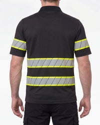 A model wears the STRAUSS Enhanced Visibility Polo Shirt in black with dark work pants and work boots, showing the shirt fit