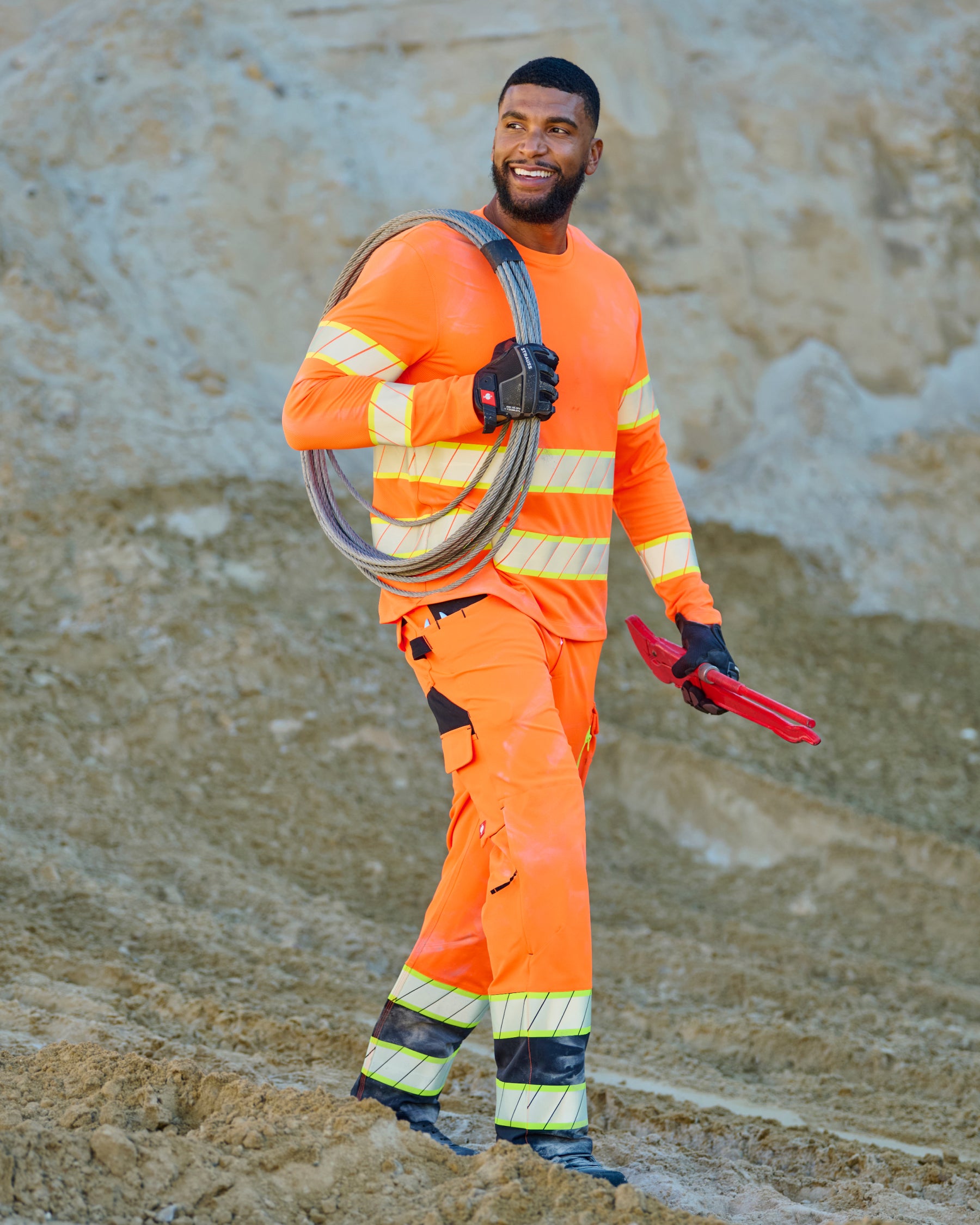 High Visibility Work Pants in neon orange/black in use, showing fit and movement