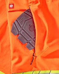 Close-up of knee pad pockets on High Visibility Work Pants in neon orange/black