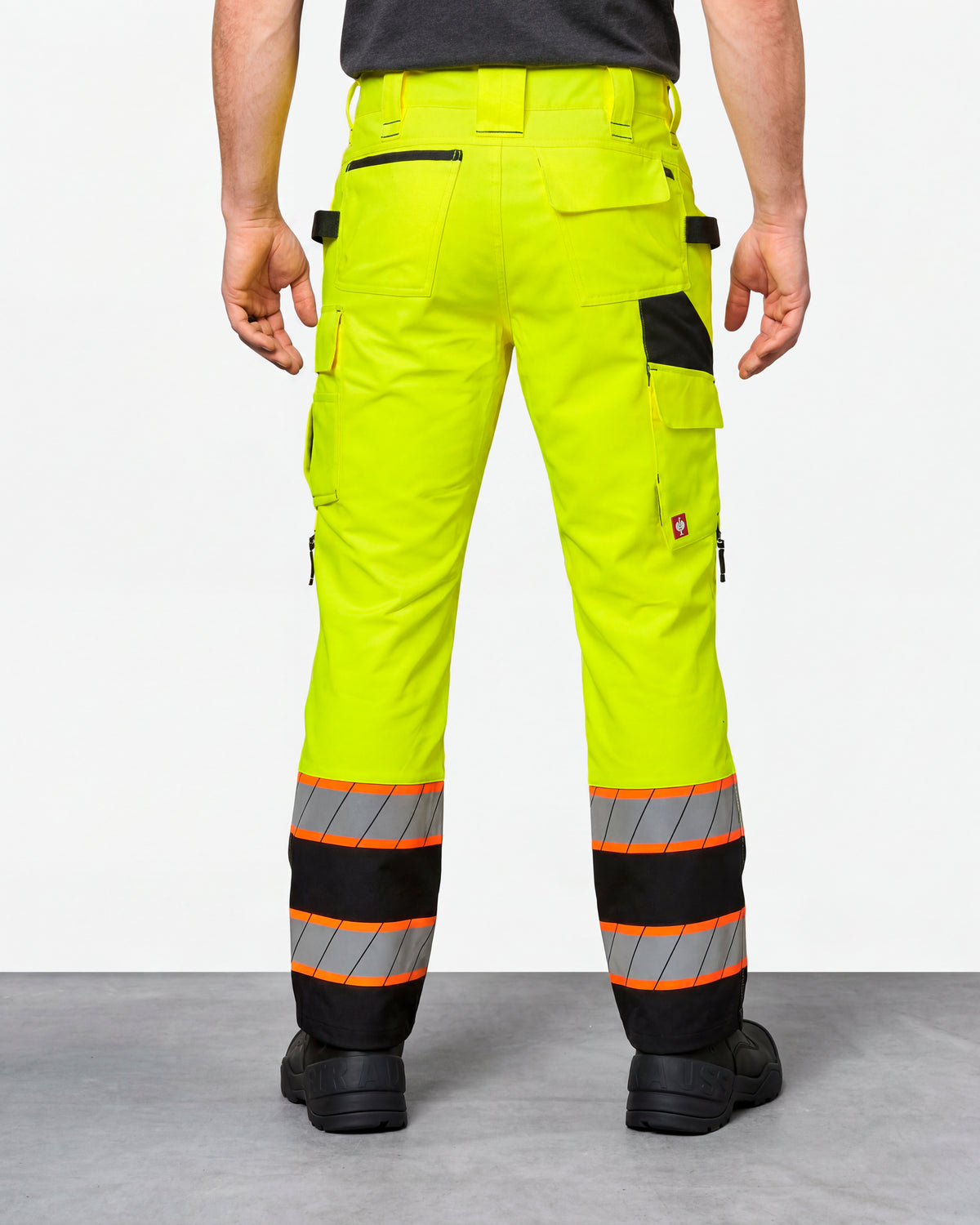 High Visibility Work Pants in neon yellow/black worn by a model, rear view