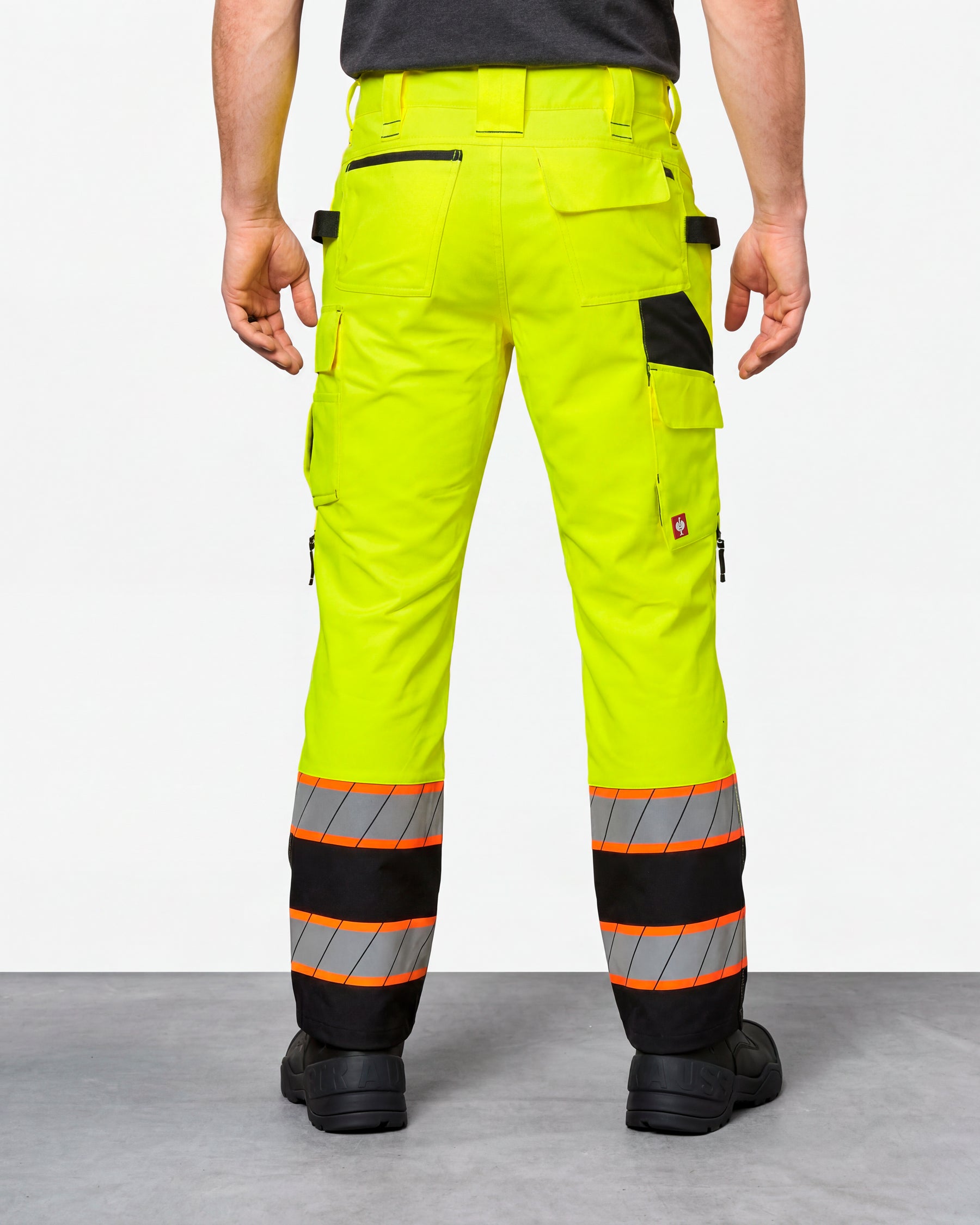High Visibility Work Pants in neon yellow/black worn by a model, rear view
