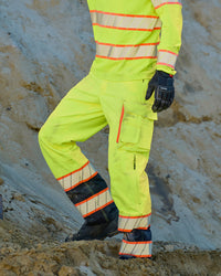High Visibility Work Pants in neon yellow/black worn in a work setting