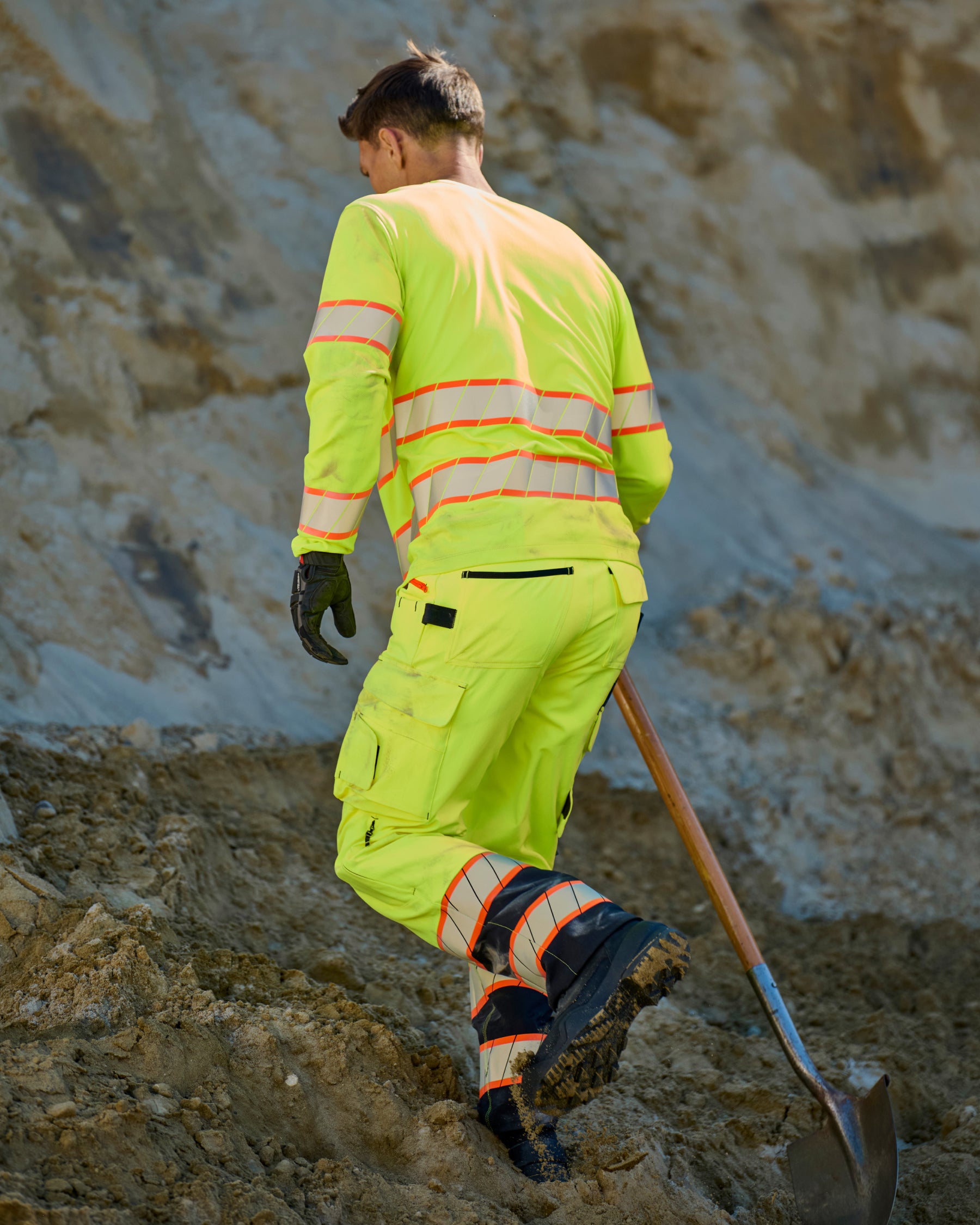 Lifestyle view of High Visibility Work Pants in neon yellow/black during work