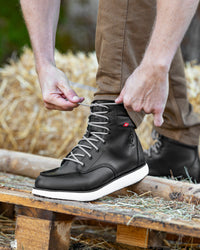STRAUSS Boulder 6-inch Soft Toe Boot in Black shown on rough jobsite ground