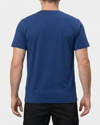 A model wears the STRAUSS Cotton Stretch T-Shirt in alkali blue with tan work pants and work boots, showing the shirt fit