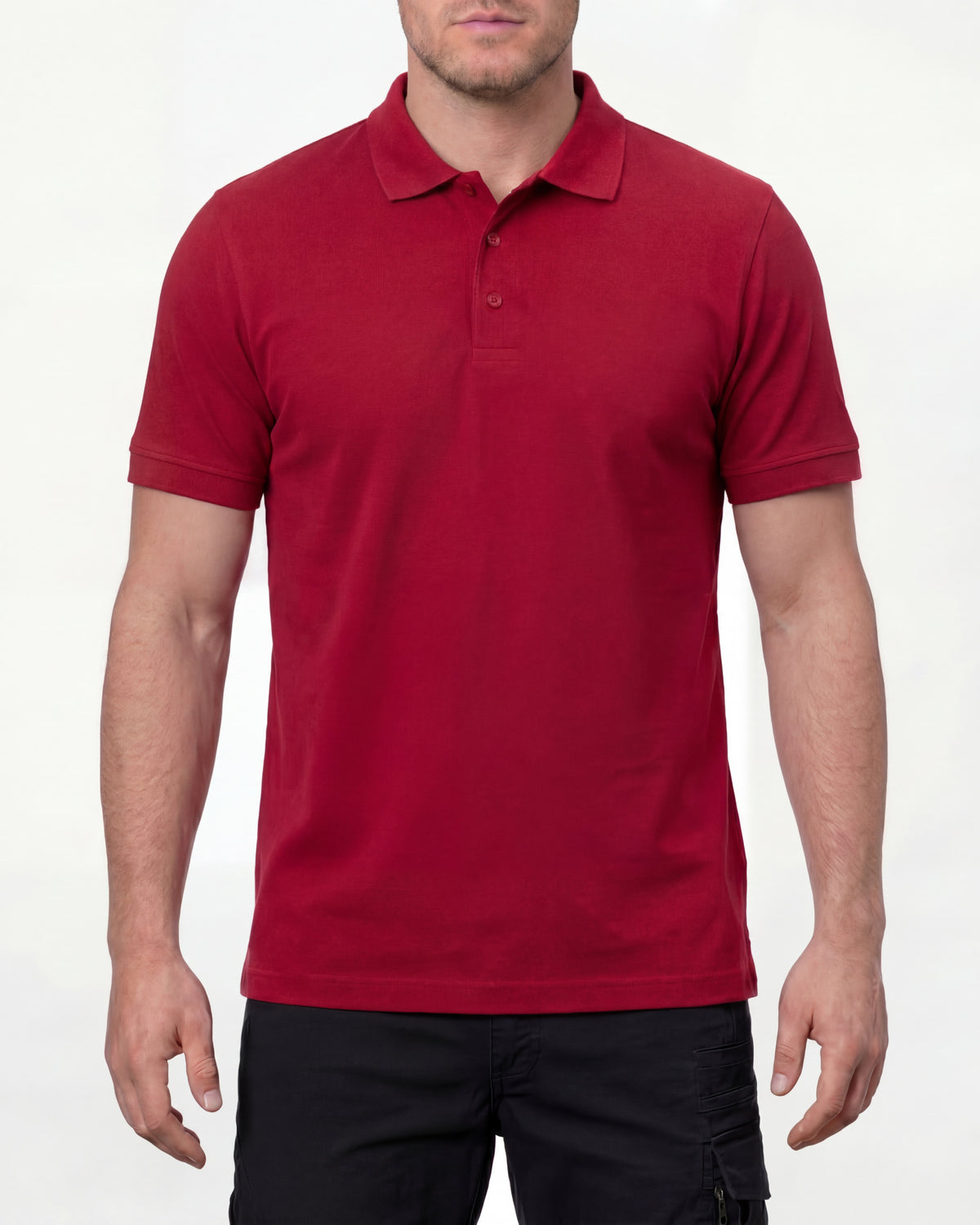 A model wears the STRAUSS Cotton Stretch Polo Shirt in fire red with tan work pants and work boots in a studio product scene