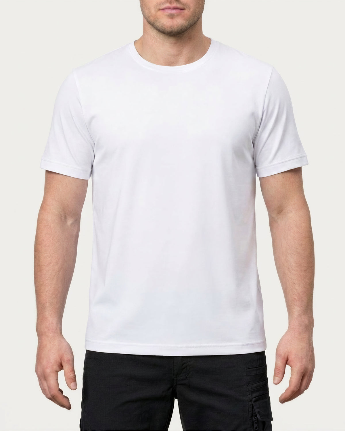 A model wears the STRAUSS Cotton Stretch T-Shirt in white with tan work pants and work boots in a studio product scene