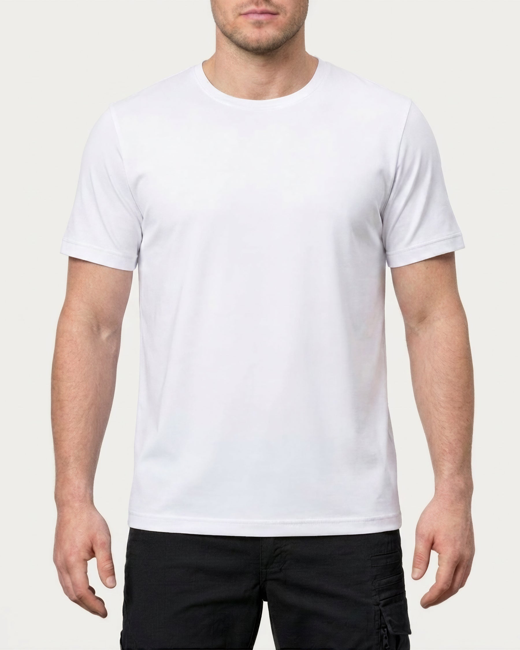A model wears the STRAUSS Cotton Stretch T-Shirt in white with tan work pants and work boots in a studio product scene
