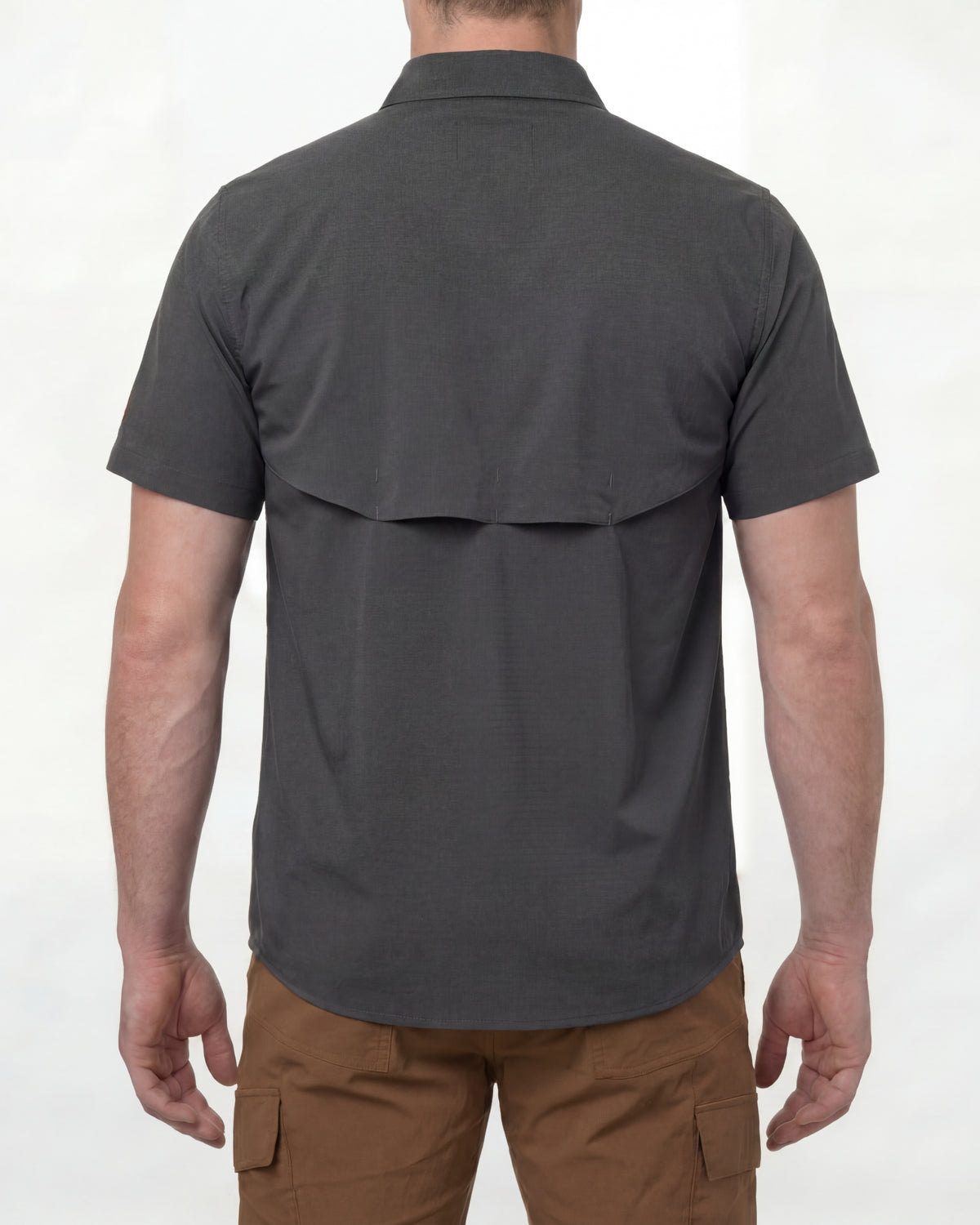 A model wears the STRAUSS e.s.taktik Stretch Ripstop Short Sleeve Work Shirt in carbon gray open over a T-shirt with work pants and work boots, showing the shirt fit
