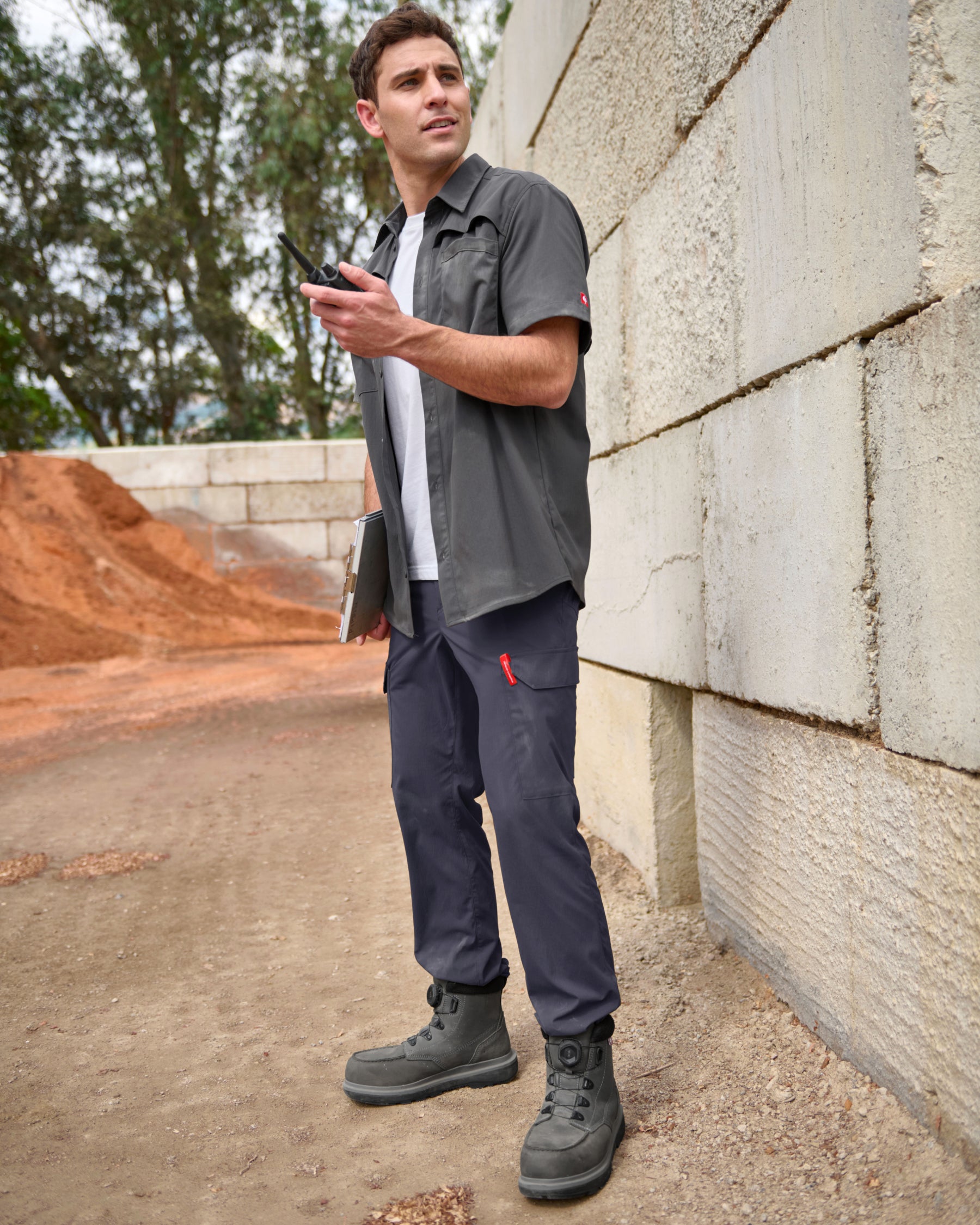 A worker wears the STRAUSS e.s.taktik Stretch Ripstop Short Sleeve Work Shirt in carbon gray