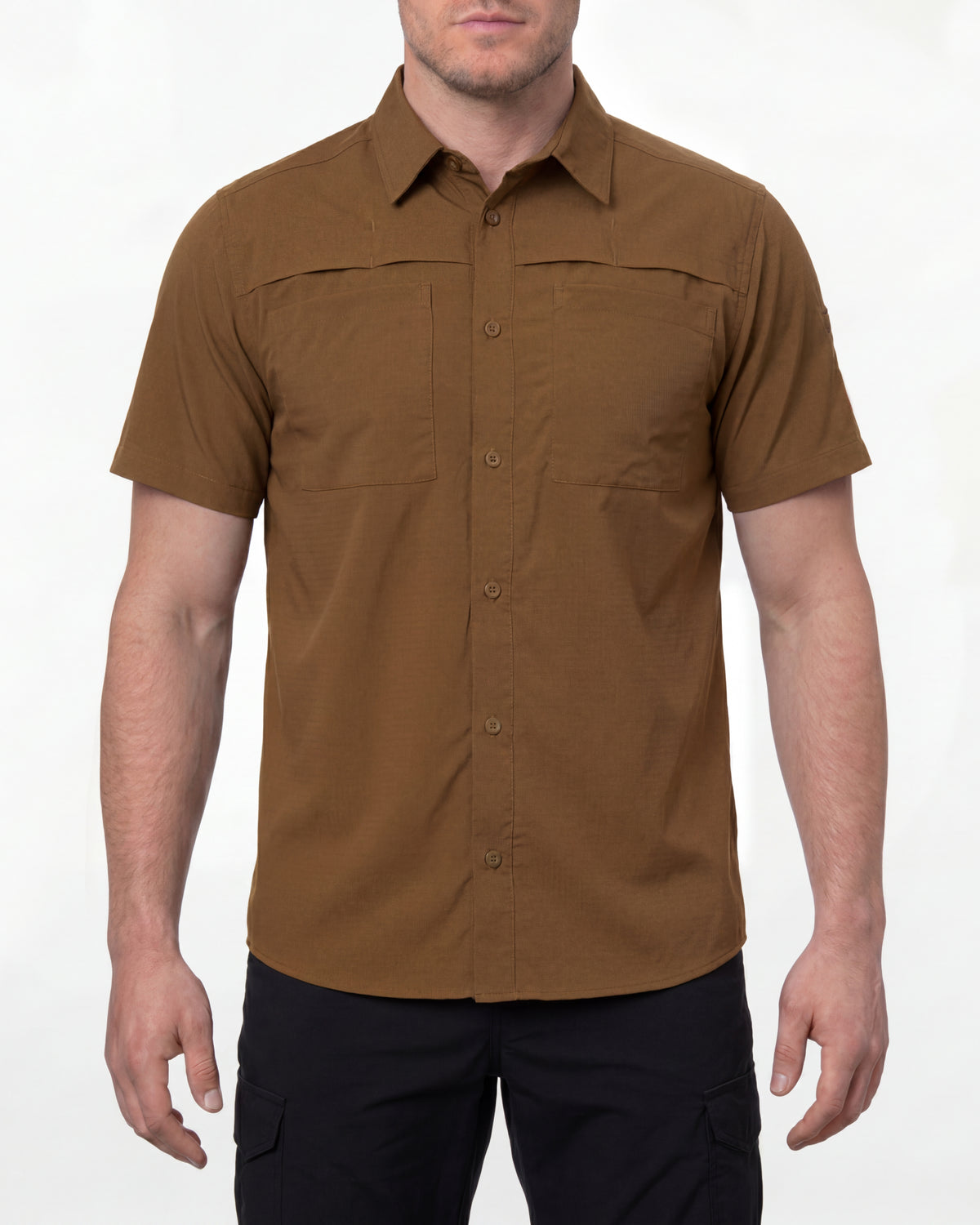 A model wears the STRAUSS e.s.taktik Stretch Ripstop Short Sleeve Work Shirt in desert brown open over a T-shirt with work pants and work boots in a studio product scene