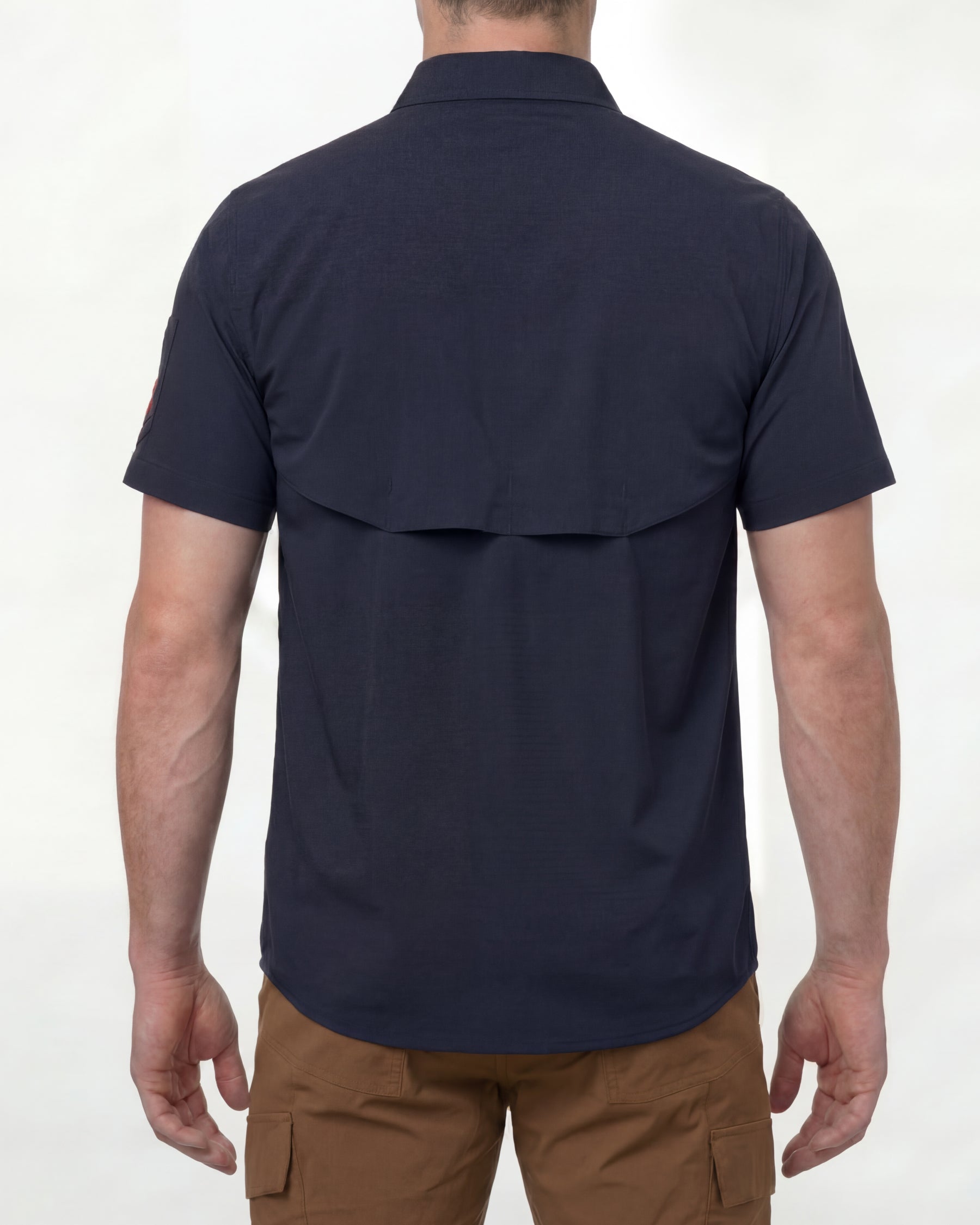 A model wears the STRAUSS e.s.taktik Stretch Ripstop Short Sleeve Work Shirt in nero blue open over a T-shirt with work pants and work boots, showing the shirt fit