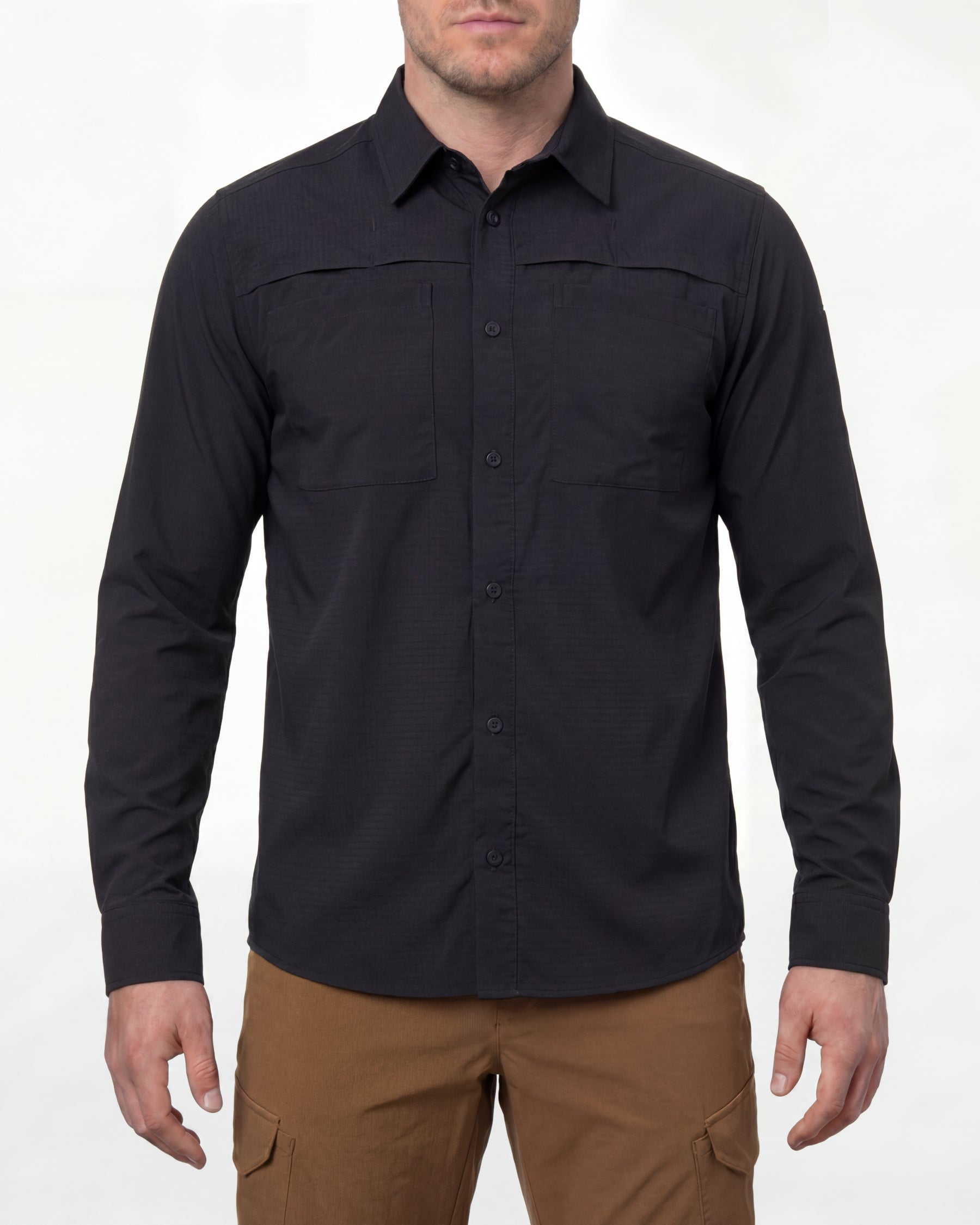 A model wears the STRAUSS e.s.taktik Stretch Ripstop Long Sleeve Work Shirt in black open over a T-shirt with work pants and work boots in a studio product scene