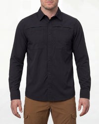 A model wears the STRAUSS e.s.taktik Stretch Ripstop Long Sleeve Work Shirt in black open over a T-shirt with work pants and work boots in a studio product scene