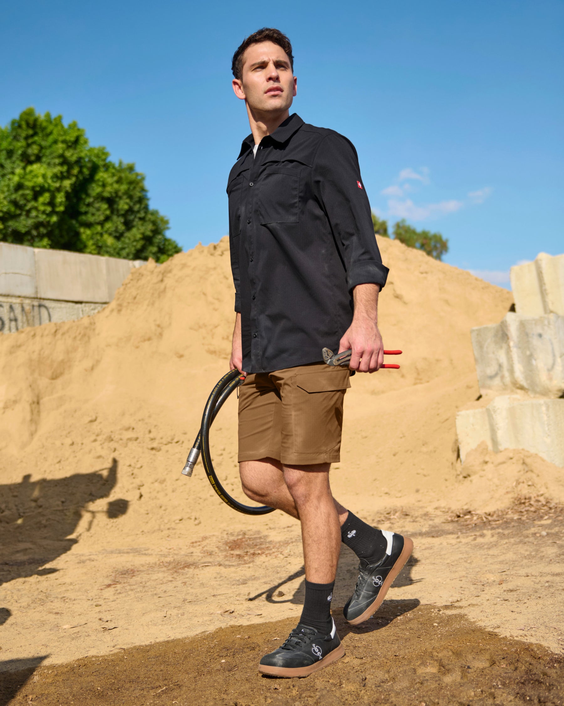A worker wears the STRAUSS e.s.taktik Stretch Ripstop Long Sleeve Work Shirt in black