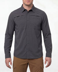A model wears the STRAUSS e.s.taktik Stretch Ripstop Long Sleeve Work Shirt in carbon gray open over a T-shirt with work pants and work boots in a studio product scene