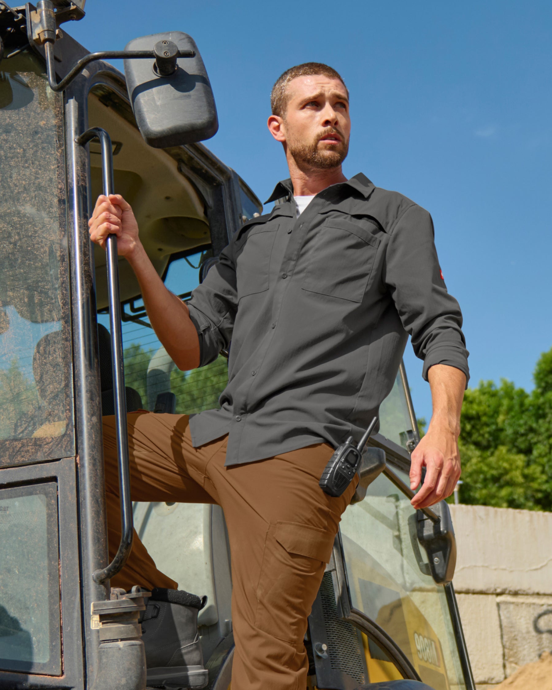 A worker wears the STRAUSS e.s.taktik Stretch Ripstop Long Sleeve Work Shirt in carbon gray