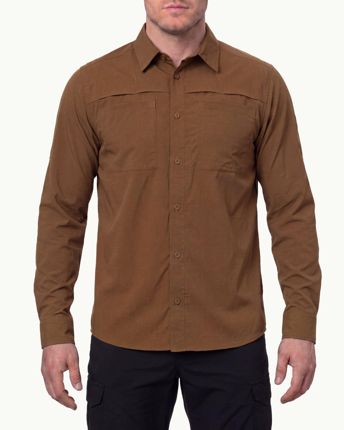 A model wears the STRAUSS e.s.taktik Stretch Ripstop Long Sleeve Work Shirt in desert brown open over a T-shirt with work pants and work boots in a studio product scene