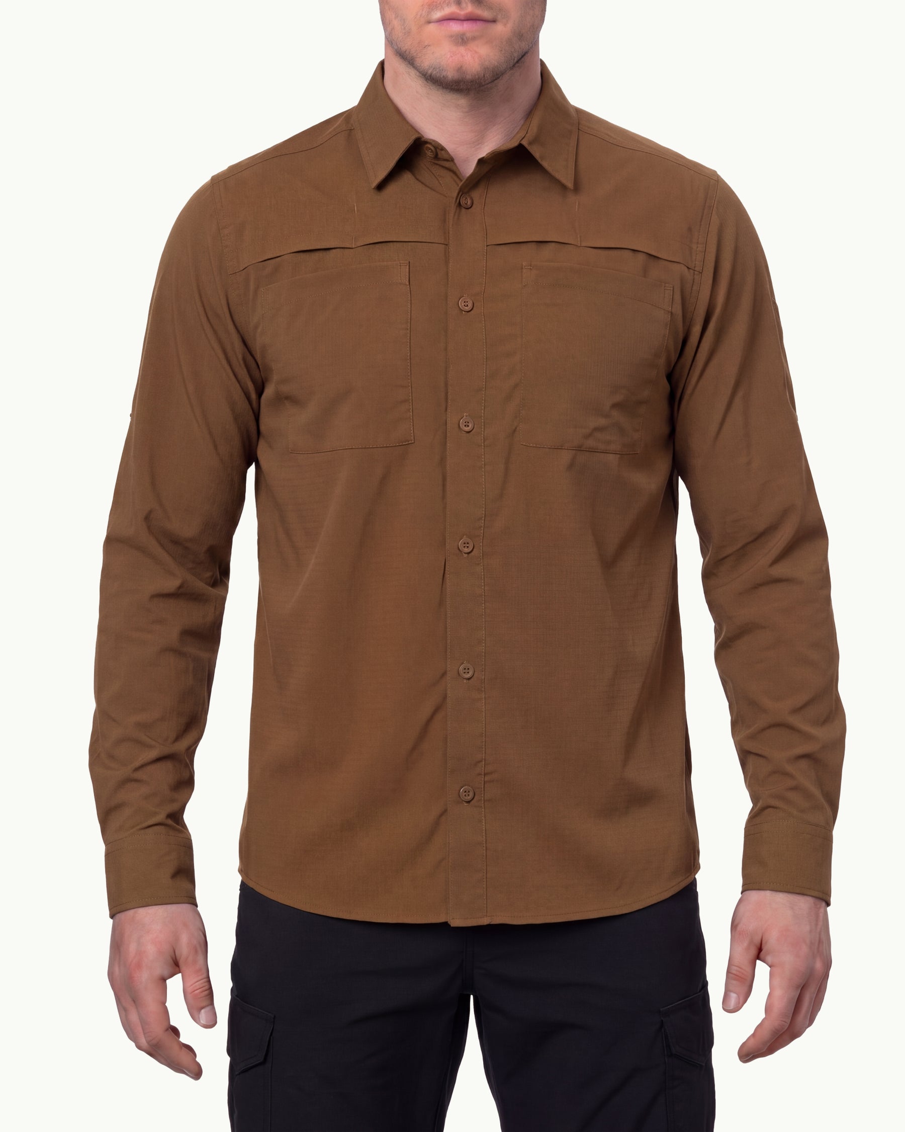 A model wears the STRAUSS e.s.taktik Stretch Ripstop Long Sleeve Work Shirt in desert brown open over a T-shirt with work pants and work boots in a studio product scene