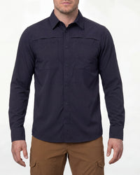 A model wears the STRAUSS e.s.taktik Stretch Ripstop Long Sleeve Work Shirt in nero blue open over a T-shirt with work pants and work boots in a studio product scene