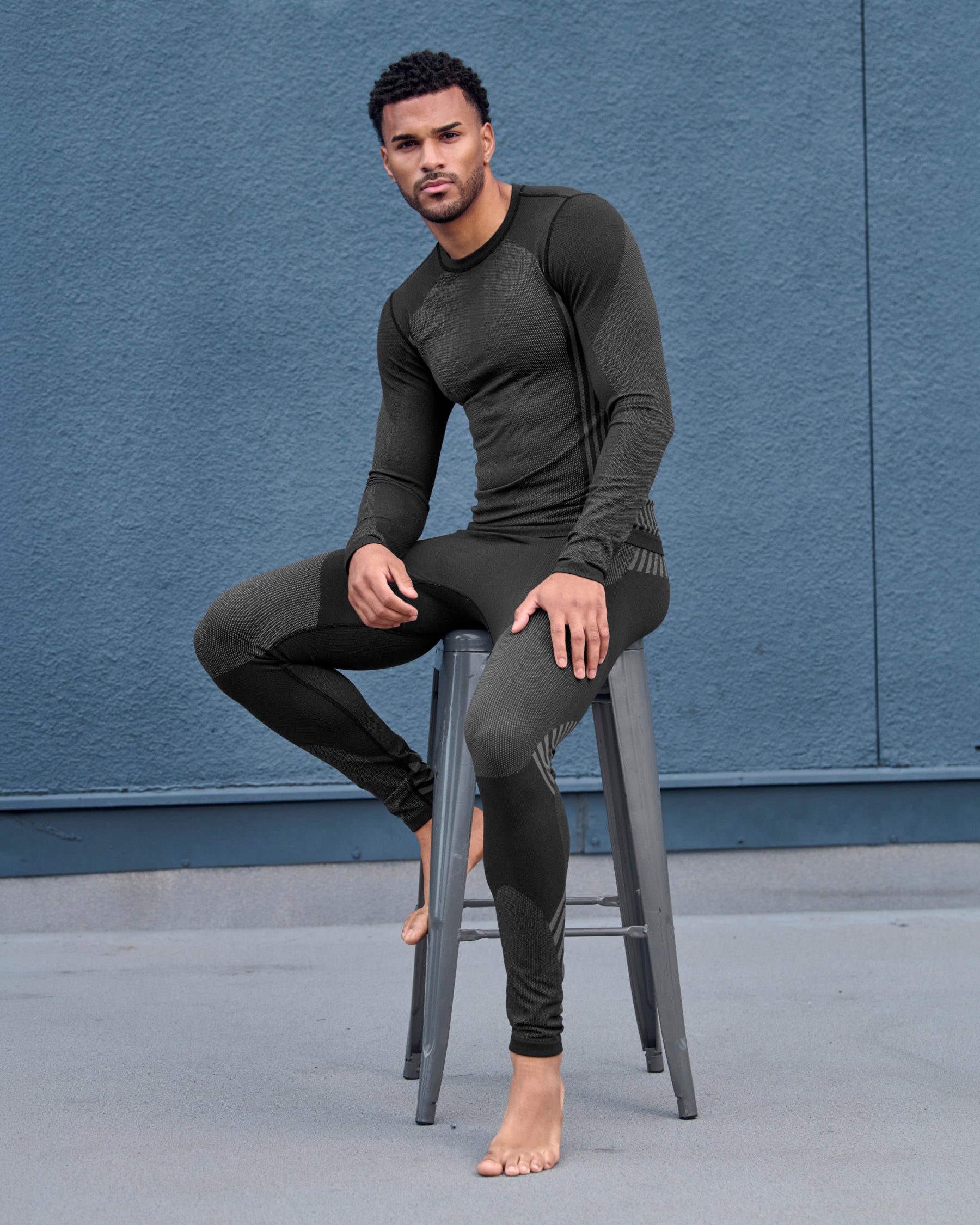 A worker wears the STRAUSS e.s.trail pure Warm Seamless Thermal Long Sleeve Shirt in black and basalt gray as a base layer