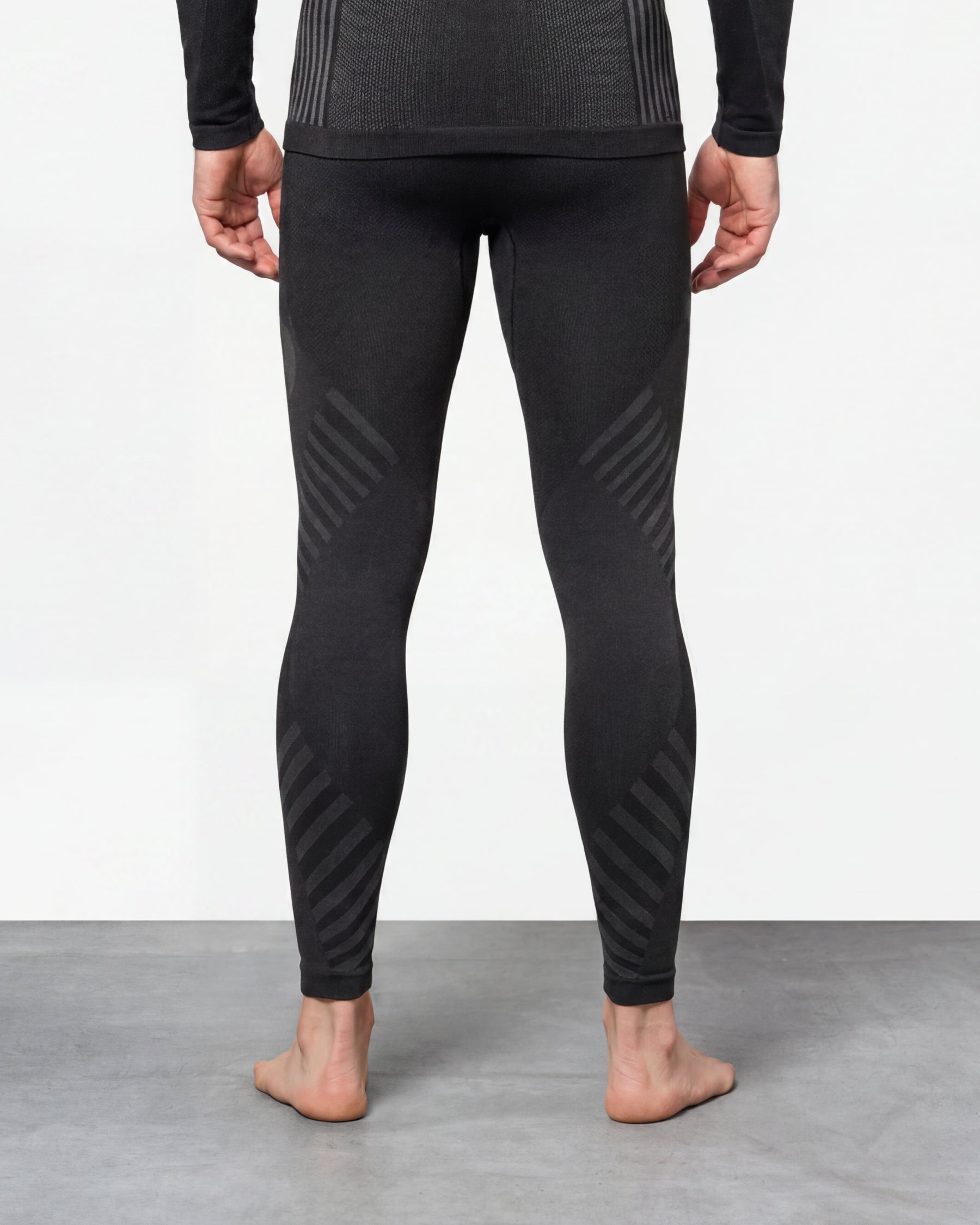 Warm Seamless Thermal Pants e.s.trail pure in black/basalt gray worn by a model, rear view