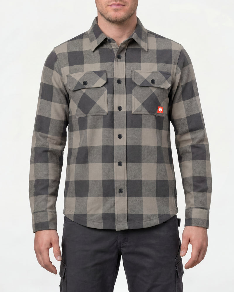 A model wears the STRAUSS e.s.iconic Flannel Work Shirt in dolphin gray and carbon gray over a T-shirt with work pants and work boots in a studio product scene