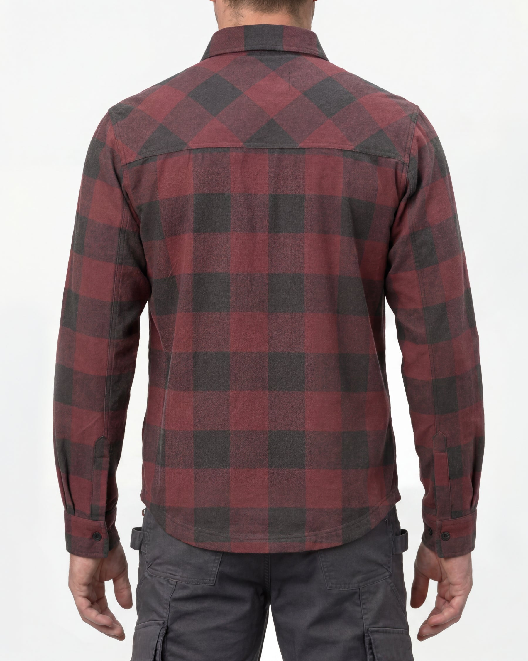 A model wears the STRAUSS e.s.iconic Flannel Work Shirt in oxid red and carbon gray over a T-shirt with work pants and work boots, showing the shirt fit