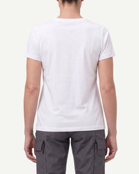 A woman wears the Women's STRAUSS Cotton Stretch T-Shirt in white with work pants and work boots, showing the shirt fit