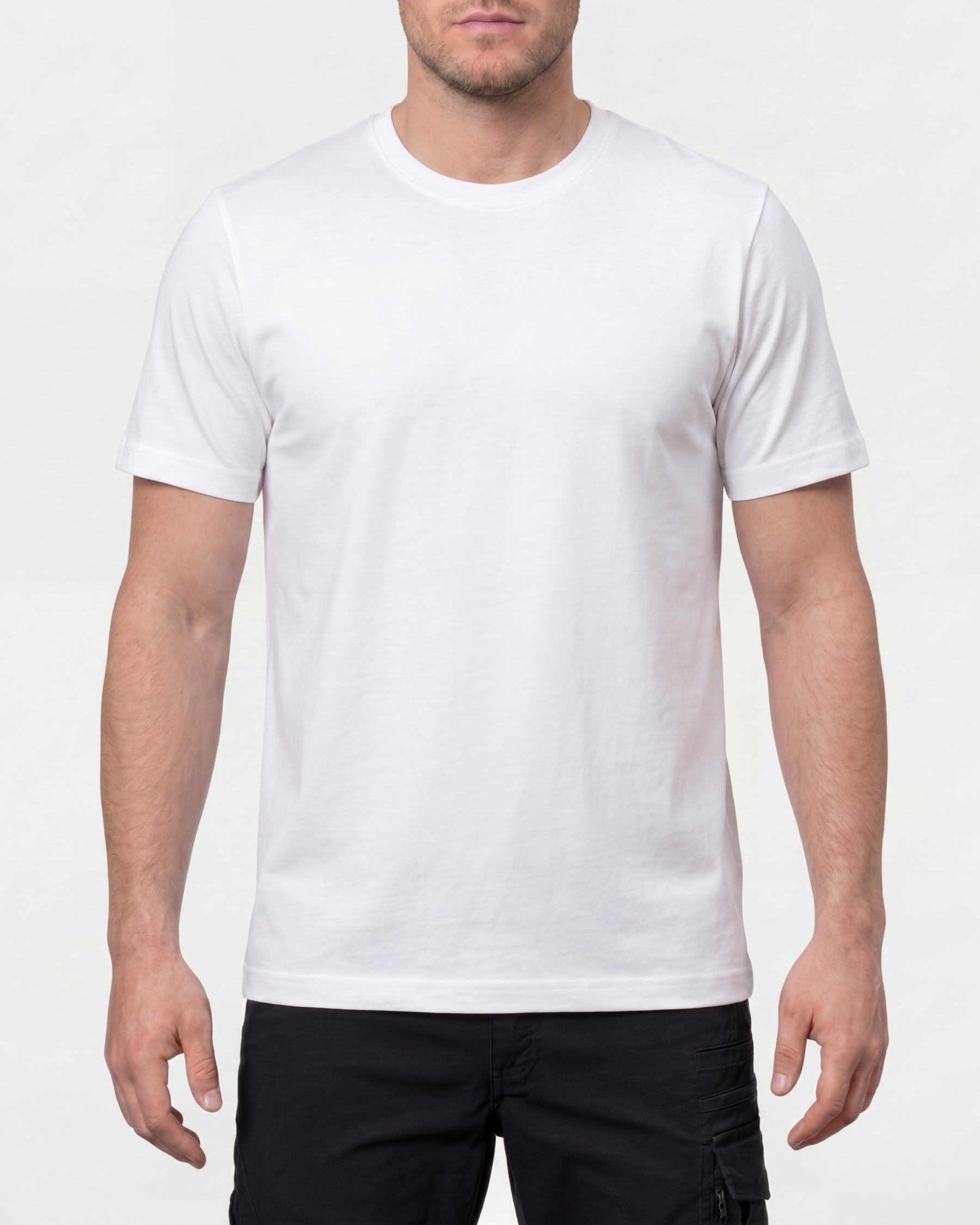 A model wears the STRAUSS Cotton T-Shirt in white with tan work pants and work boots in a studio product scene