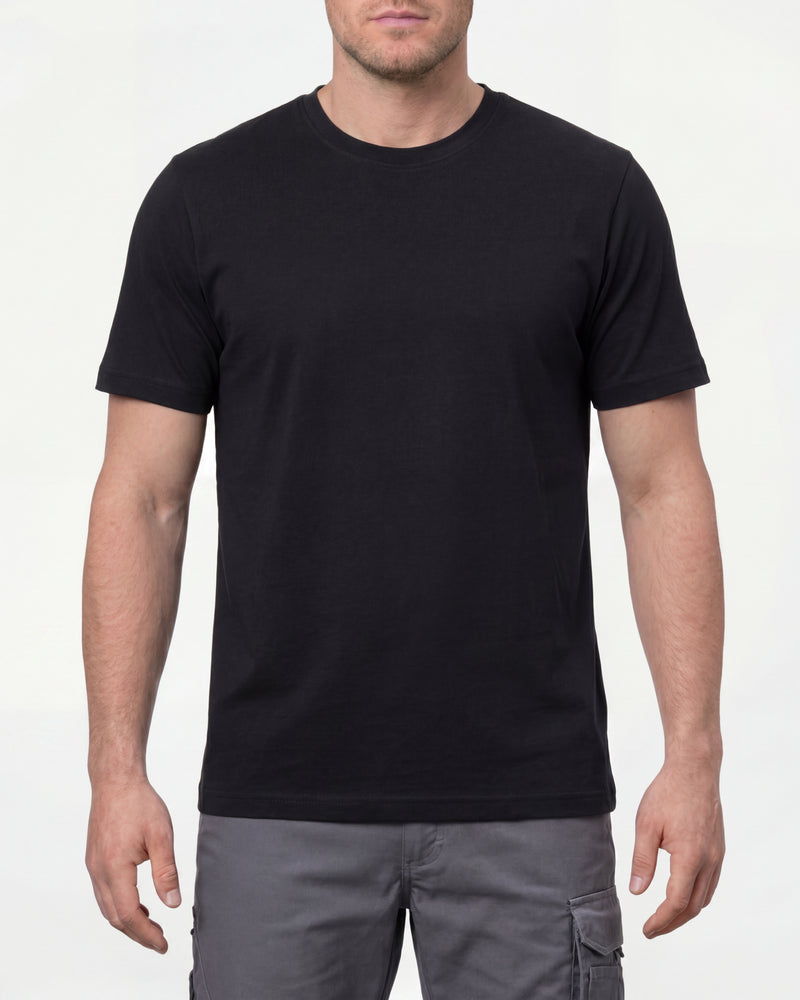 A model wears the STRAUSS Cotton T-Shirt in black with tan work pants and work boots in a studio product scene