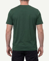A model wears the STRAUSS Cotton T-Shirt in green with tan work pants and work boots, showing the shirt fit