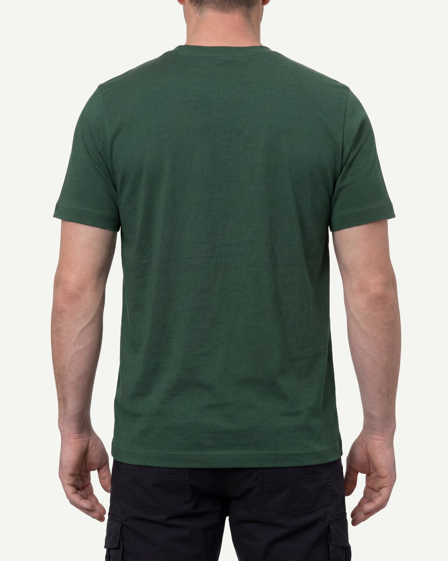 A model wears the STRAUSS Cotton T-Shirt in green with tan work pants and work boots, showing the shirt fit