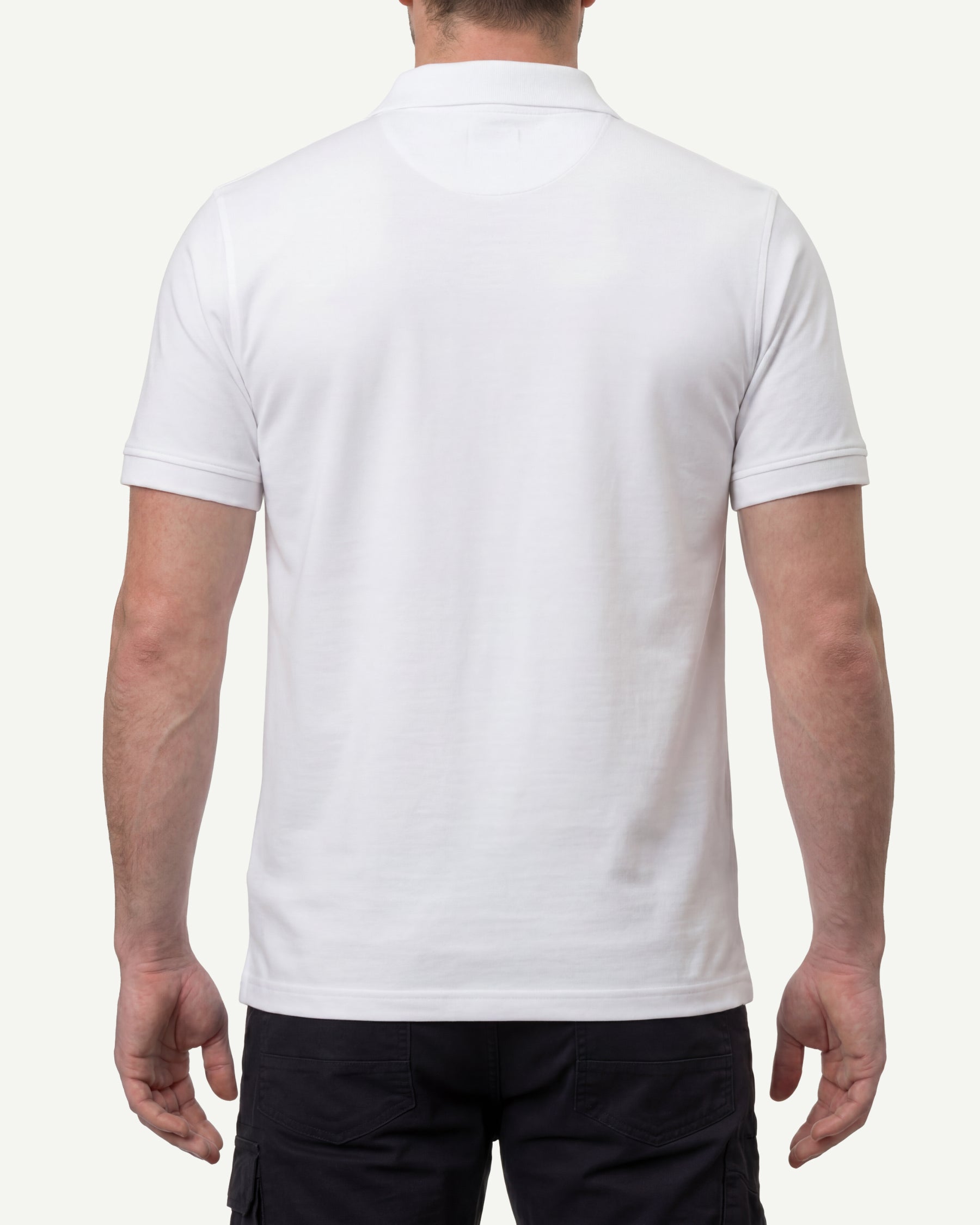 A model wears the STRAUSS Cotton Polo Shirt in white with tan work pants and work boots, showing the shirt fit
