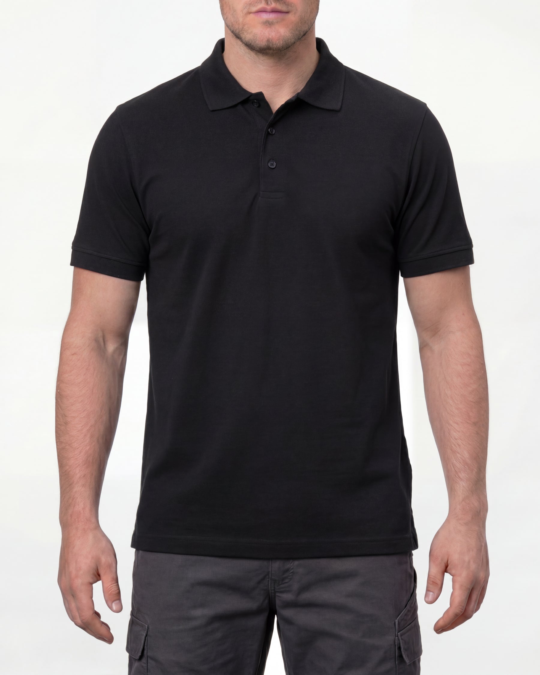 A model wears the STRAUSS Cotton Polo Shirt in black with tan work pants and work boots in a studio product scene