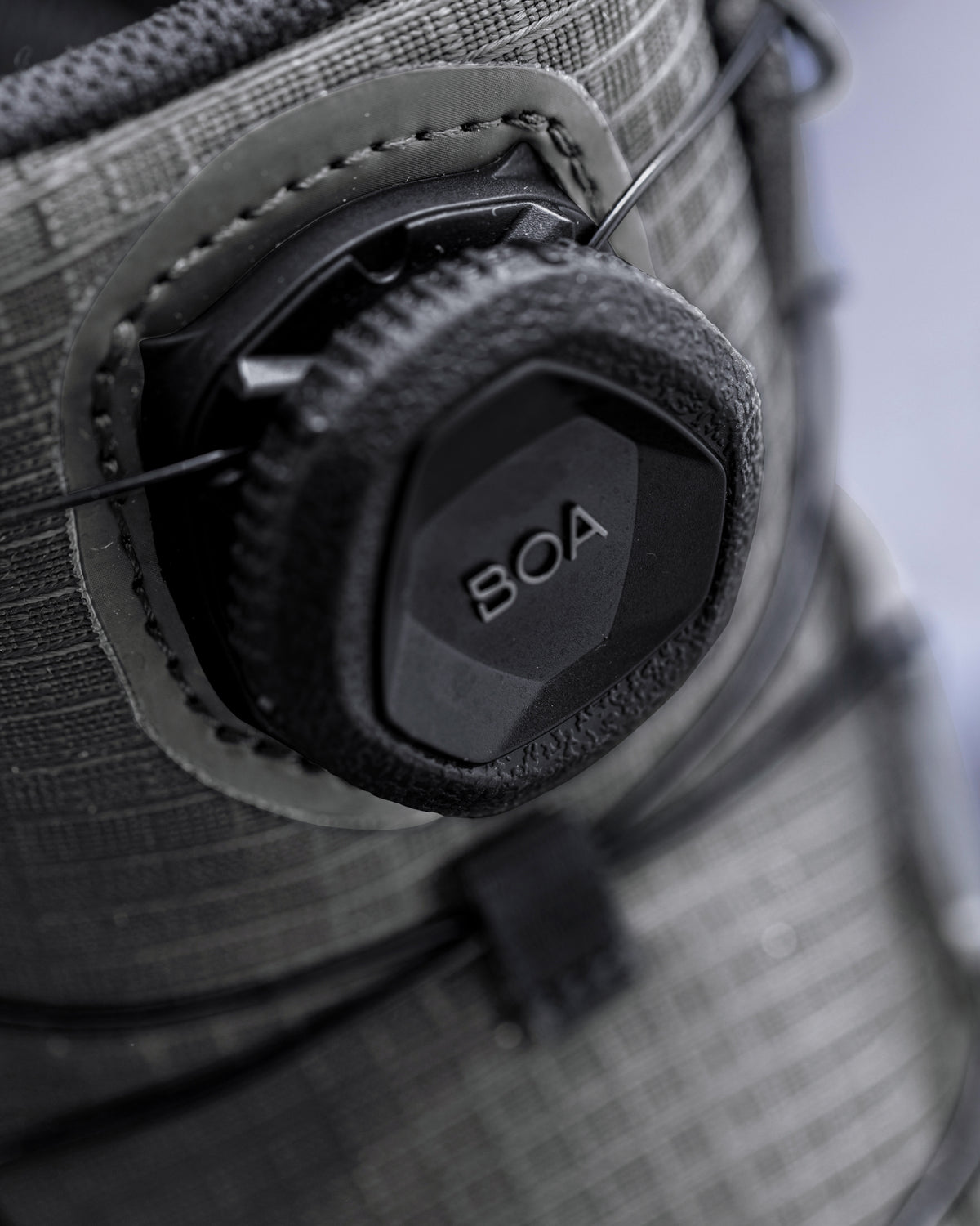 Close-up of a gray technical snowboard boot with a black BOA dial closure system.