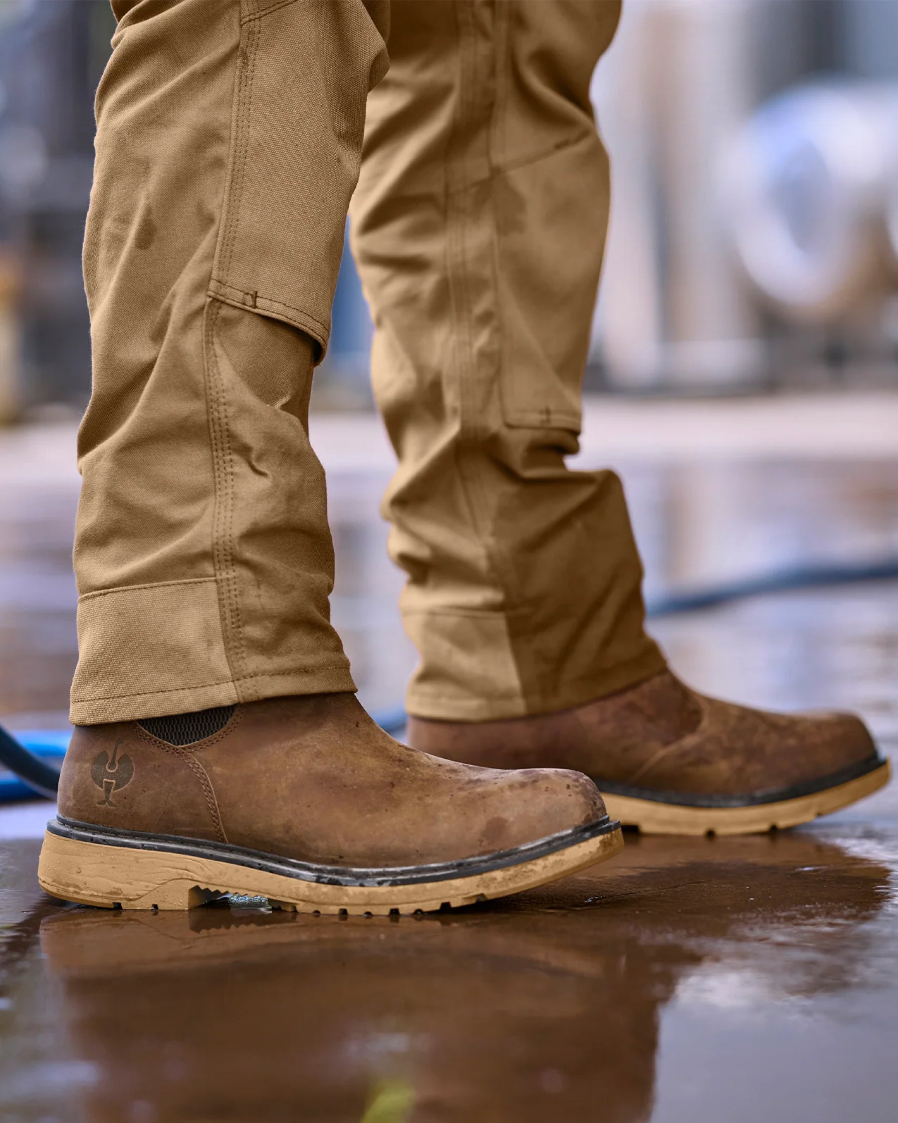 STRAUSS Woodford 6-inch Composite Toe Chelsea Boot in Carob brown shown on rough jobsite ground