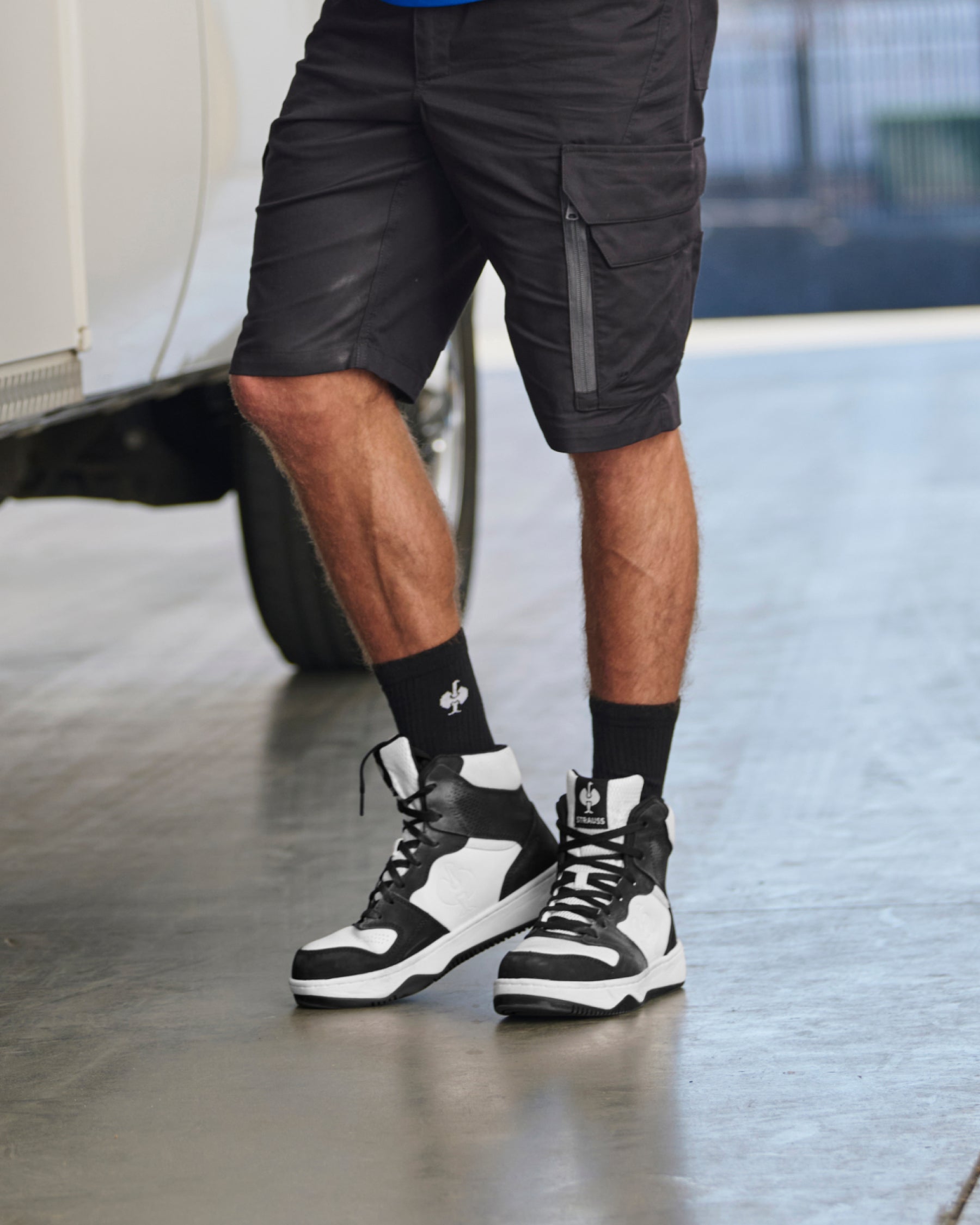 STRAUSS Eindhoven 6-inch Steel Toe Work Boot in Black and White shown on rough jobsite ground