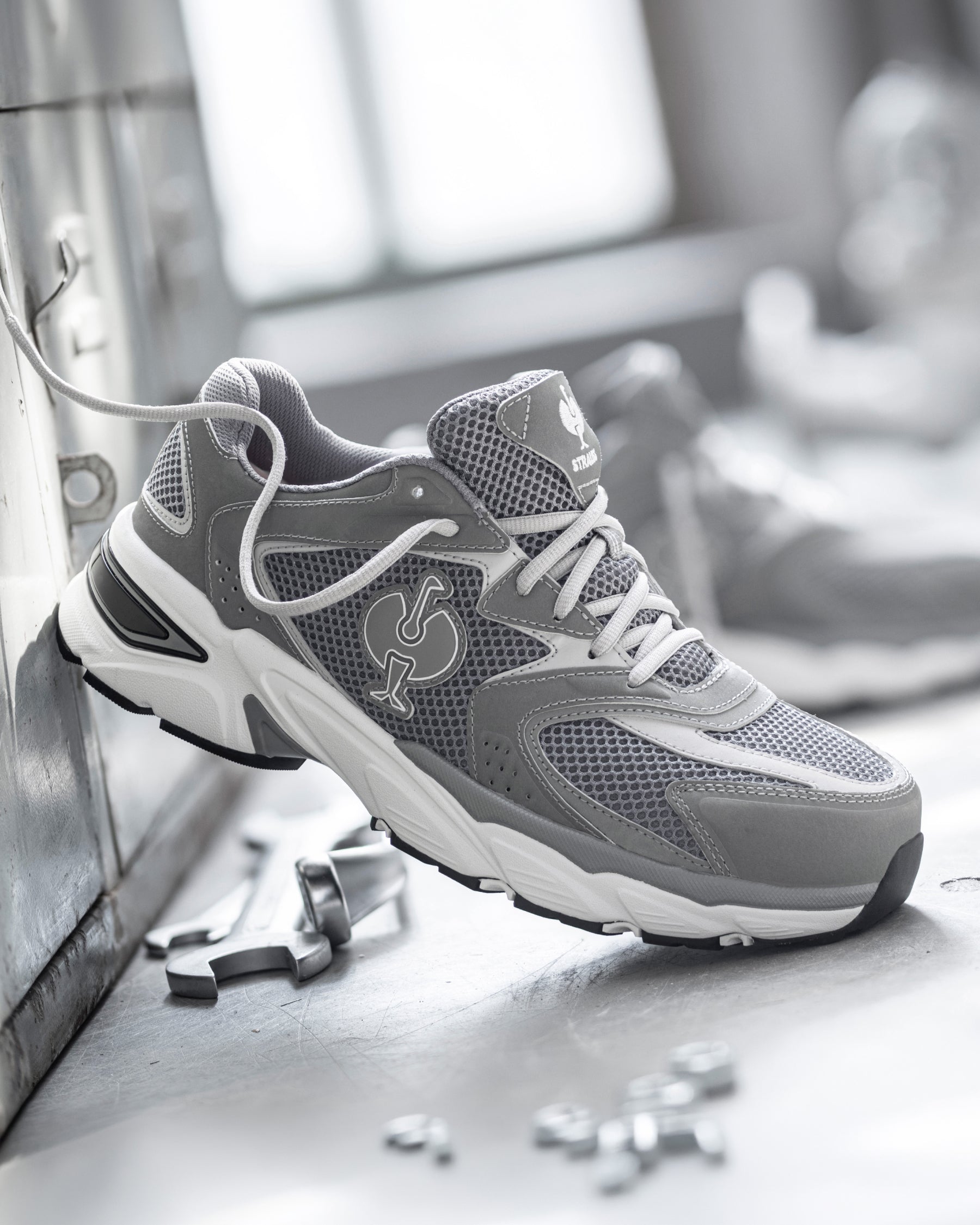 STRAUSS St. Louis Composite Toe Work Shoe in Pearl gray shown on rough jobsite ground