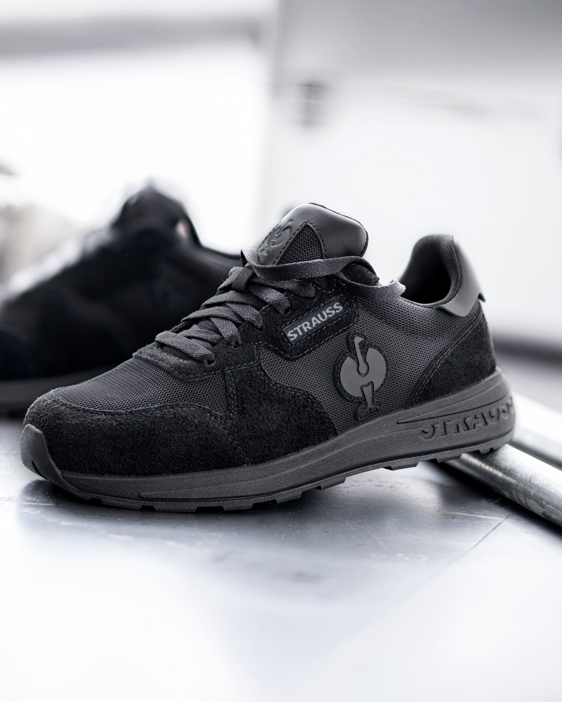 STRAUSS Canberra Steel Toe Work Shoe in Black with workwear in a jobsite scene