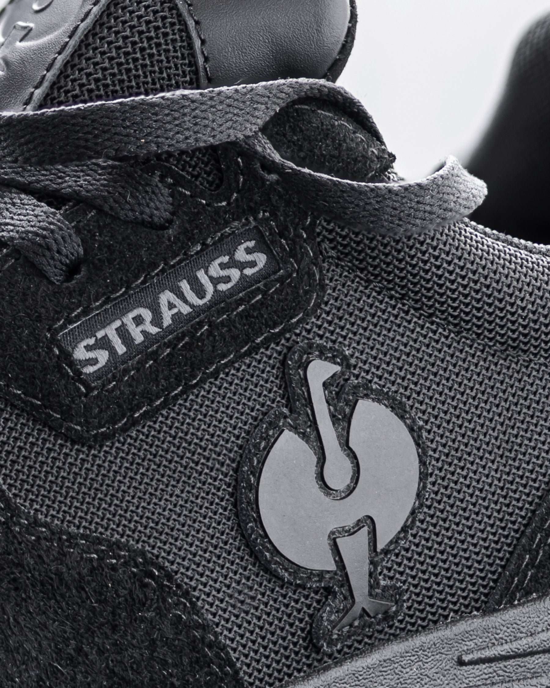 Close-up of the Canberra Steel Toe Work Shoe STRAUSS logo