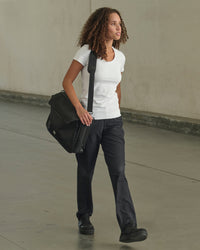 Women's Utility Cargo Work Pants in black shown in an outdoor workwear setting