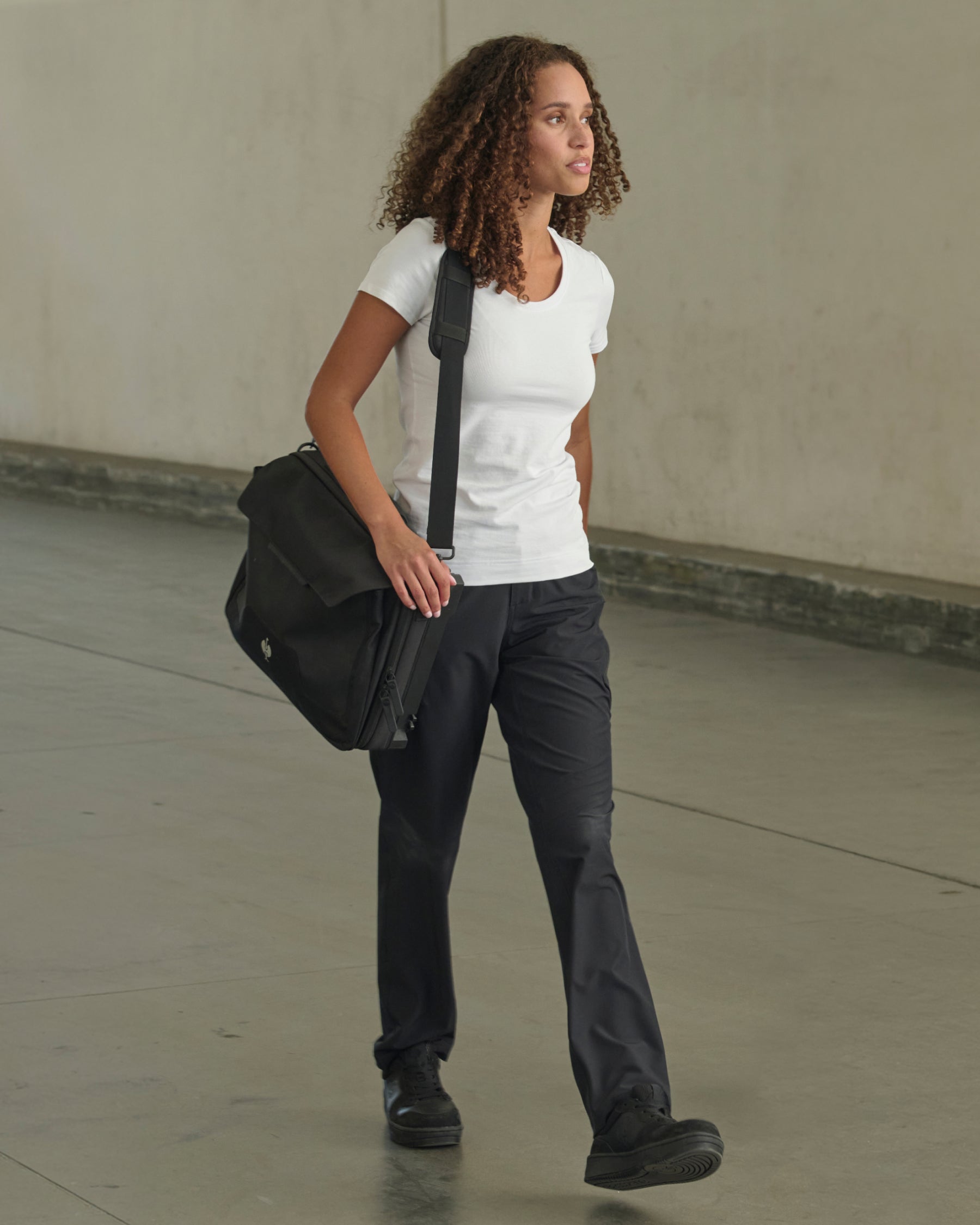Women's Utility Cargo Work Pants in black shown in an outdoor workwear setting