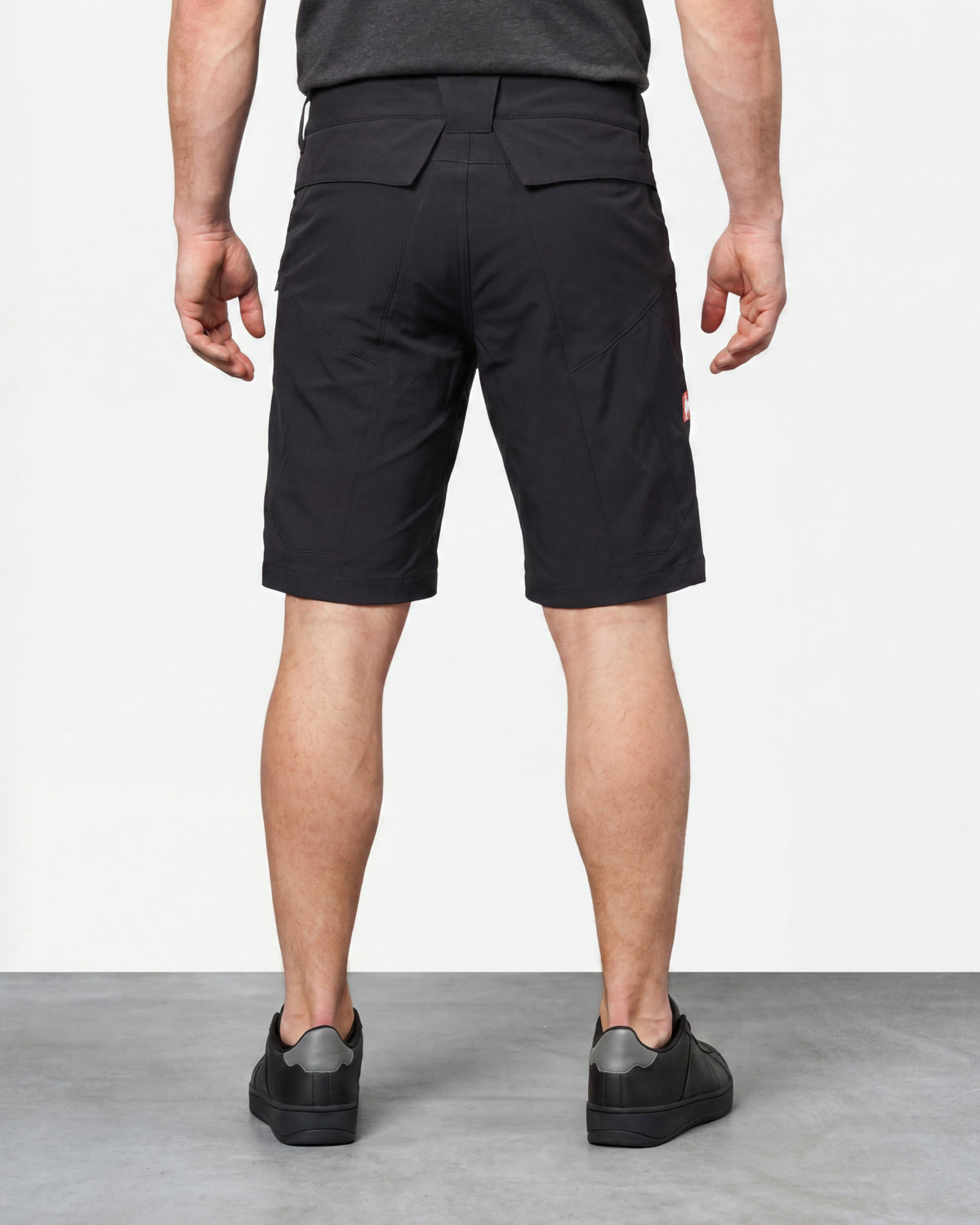 Alternate model view of Engelbert Strauss utility cargo work shorts in black, showing the side and back fit with visible utility pocket placement and workwear construction.